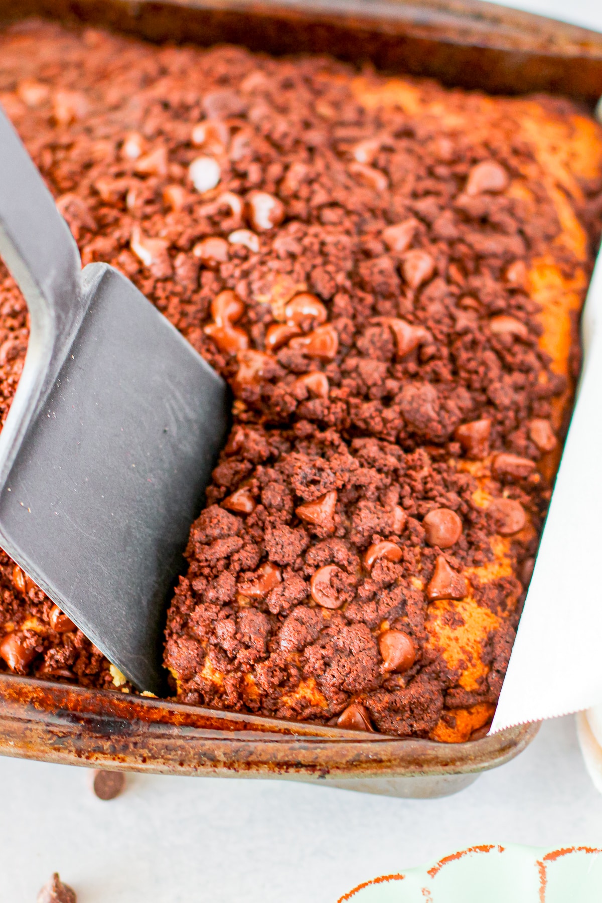 coffee cake recipe in the pan with a spatula getting a piece out