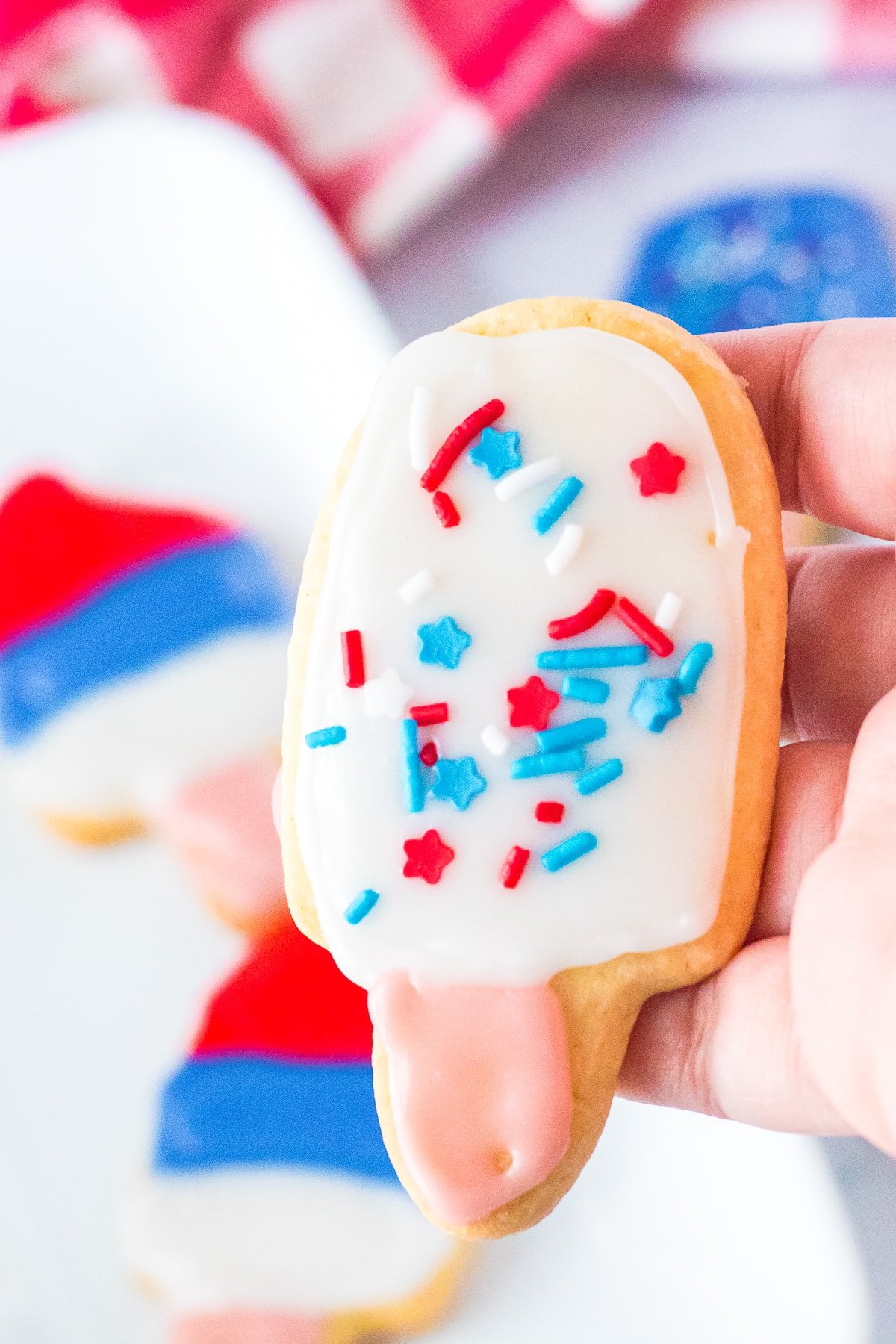 a hand holding up Cut Out Sugar Cookies Recipe in air