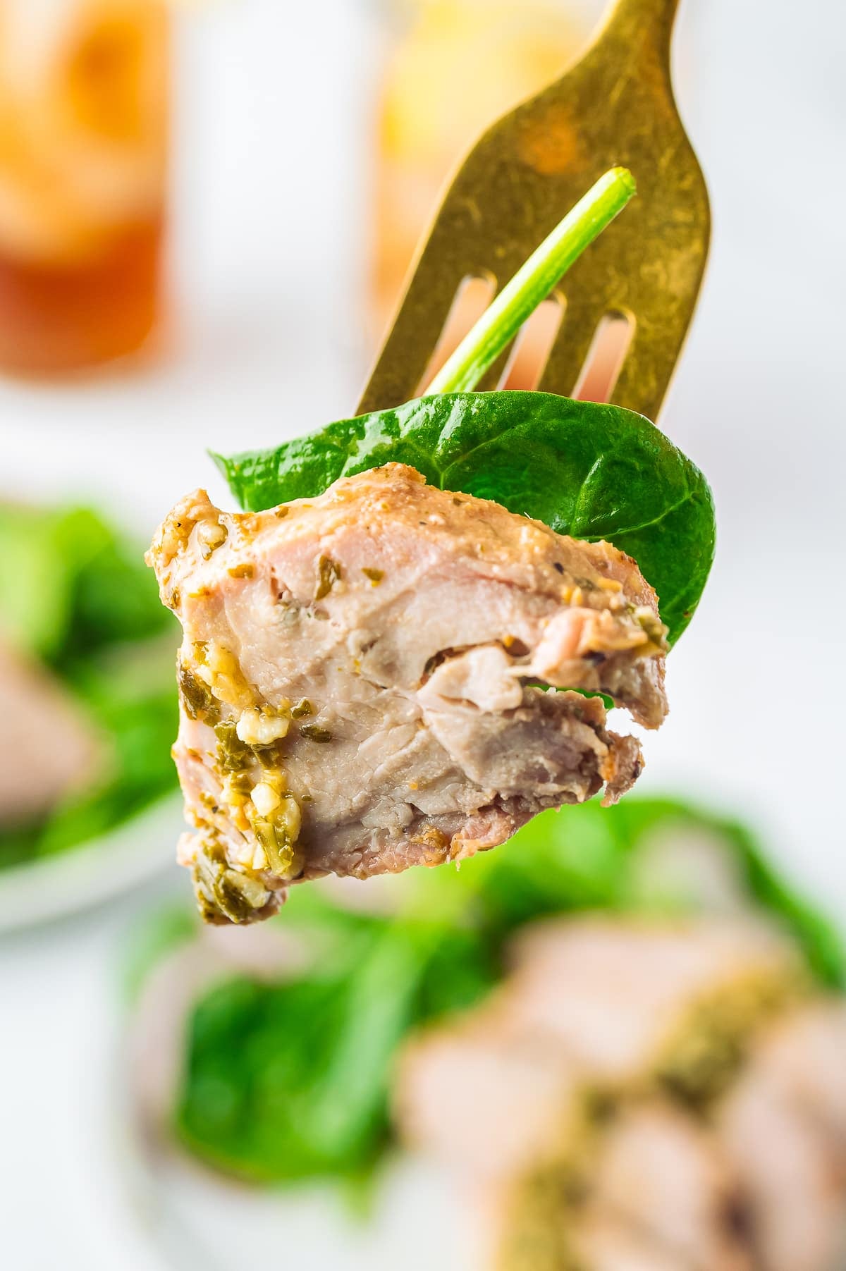 a fork with a bite of Marinated Pork Tenderloin in air