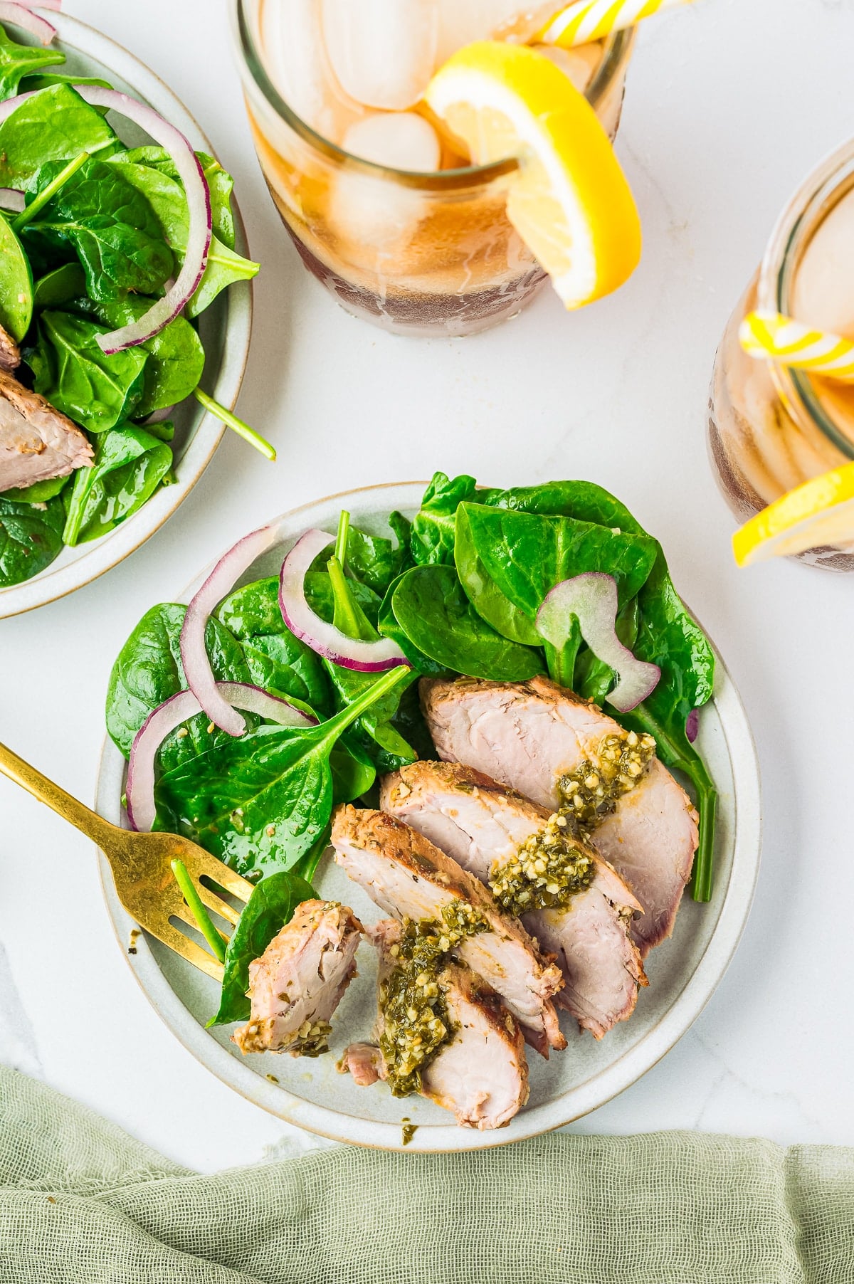 Pesto Marinated Grilled Pork Tenderloin, tender pork tenderloin, marinated in a flavorful pesto sauce and grilled. Ready in about 30 minutes! Recipe from ThisSillyGirlsKitchen.com overhead image Marinated Pork Tenderloin plated with salad