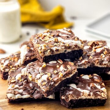 A stack of Mississippi mud brownie bars layered with marshmallow, chocolate sauce, and pecans.