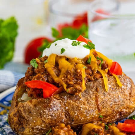 A loaded taco baked potato topped with seasoned beef, cheese, sour cream, and tomatoes.