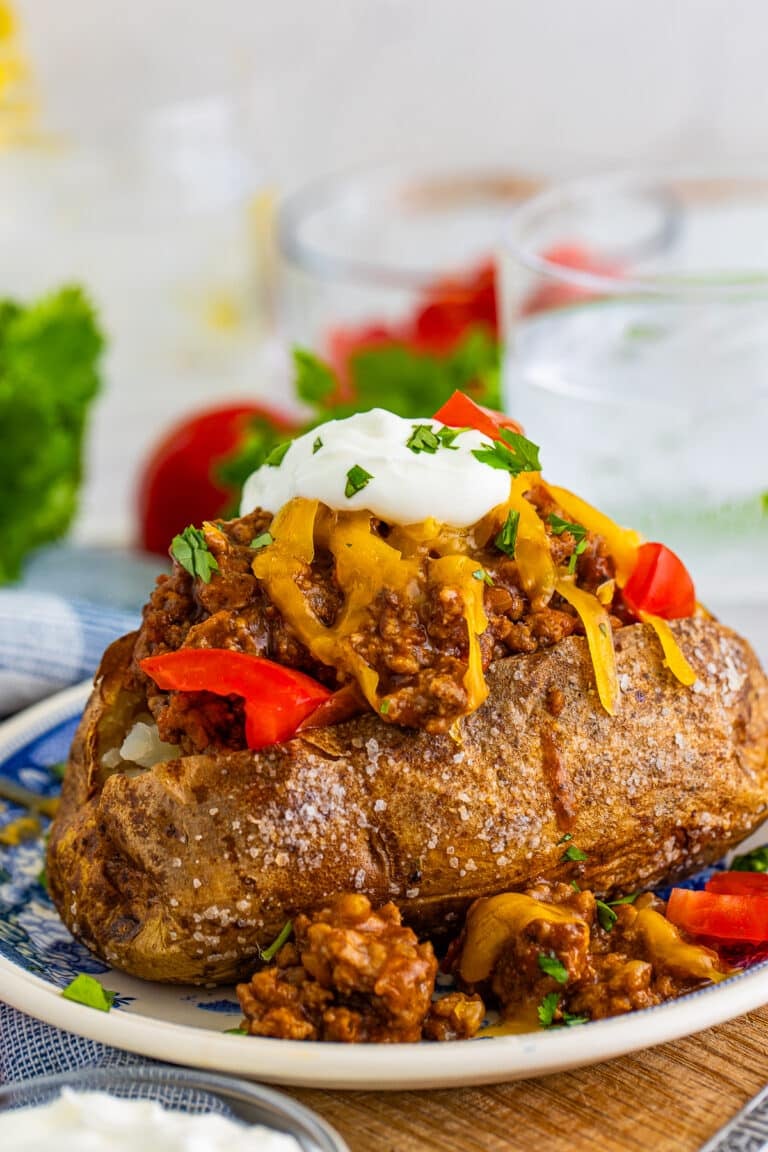 A loaded taco baked potato topped with seasoned beef, cheese, sour cream, and tomatoes.