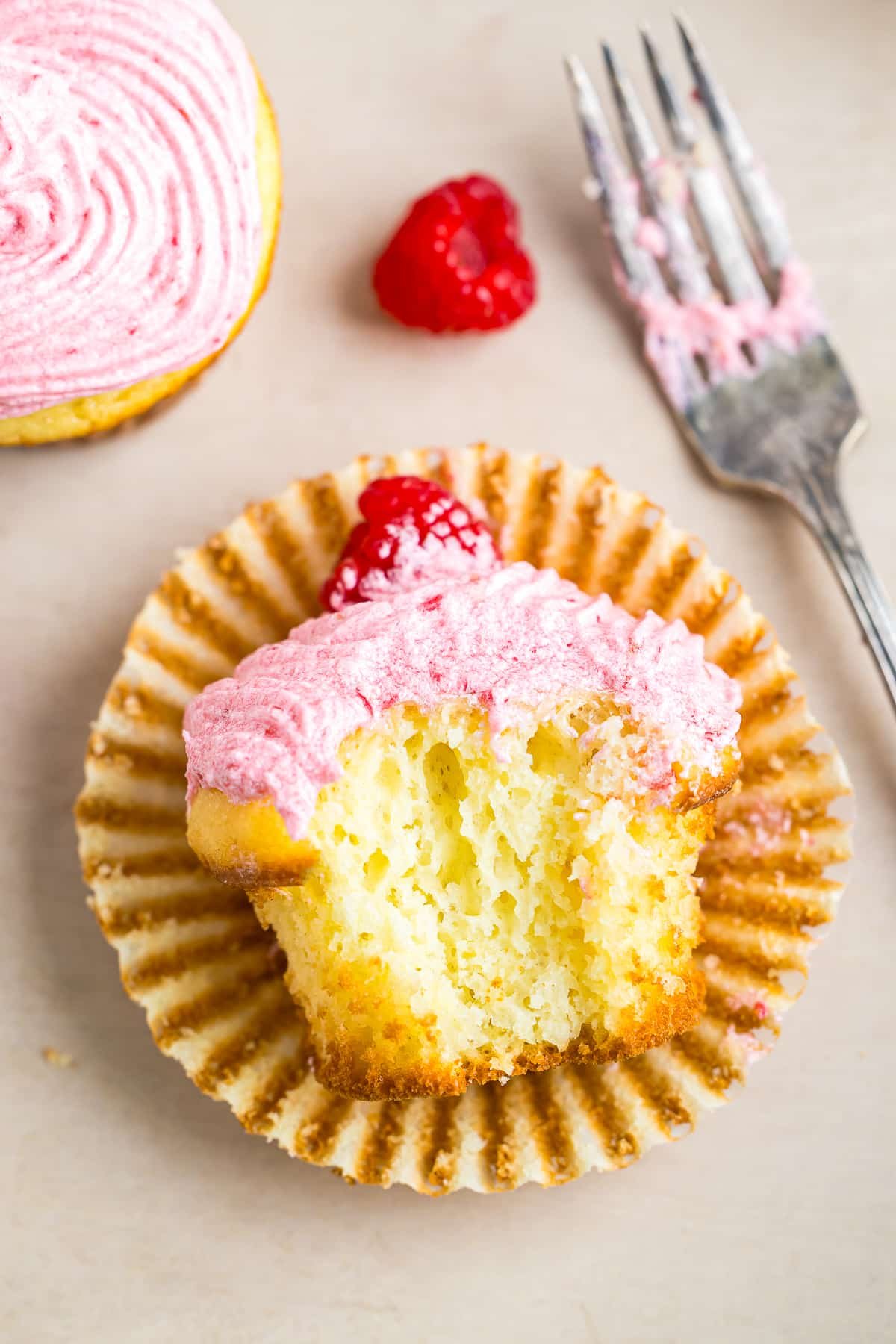 Raspberry Cupcakes on its side with a bite taken out