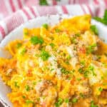 A bowl of one pot lasagna with bowtie pasta, melted cheese, and parsley.