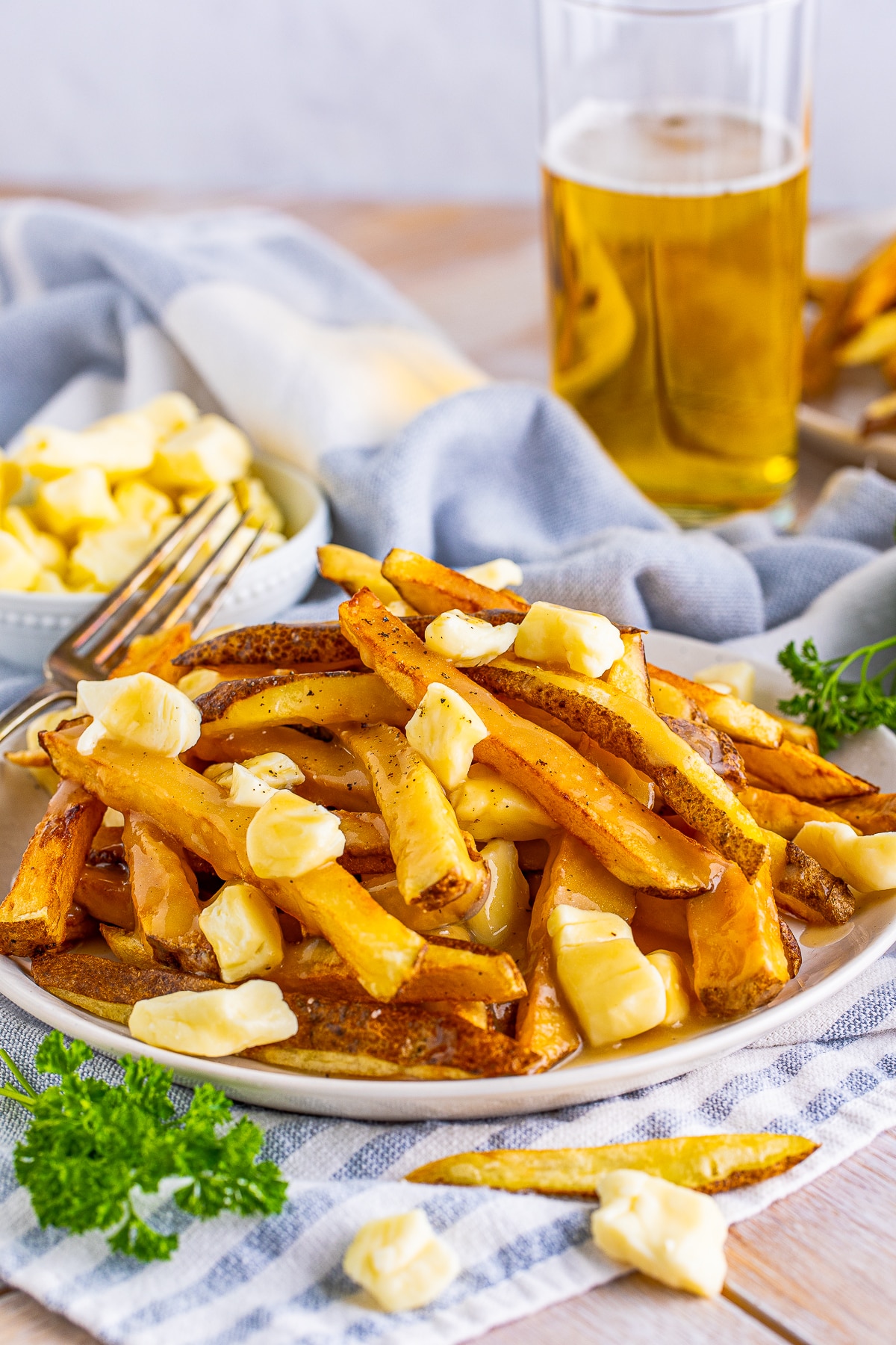 Poutine Recipe on white plate with blue linen