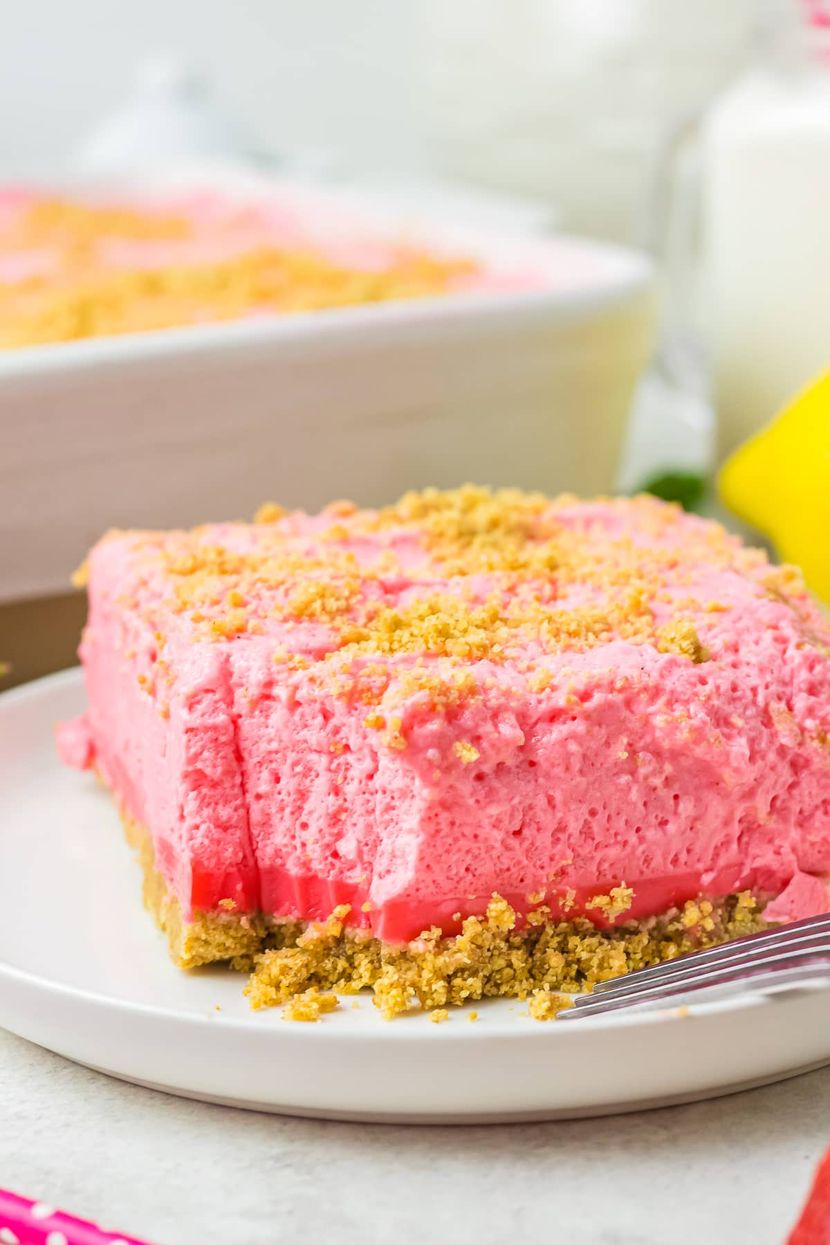a slice of Woolworth Cake on a white plate with a bite taken out
