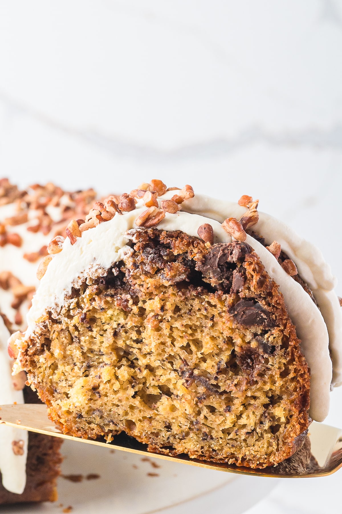 a slice of Banana Bundt Cake on a cake server in air