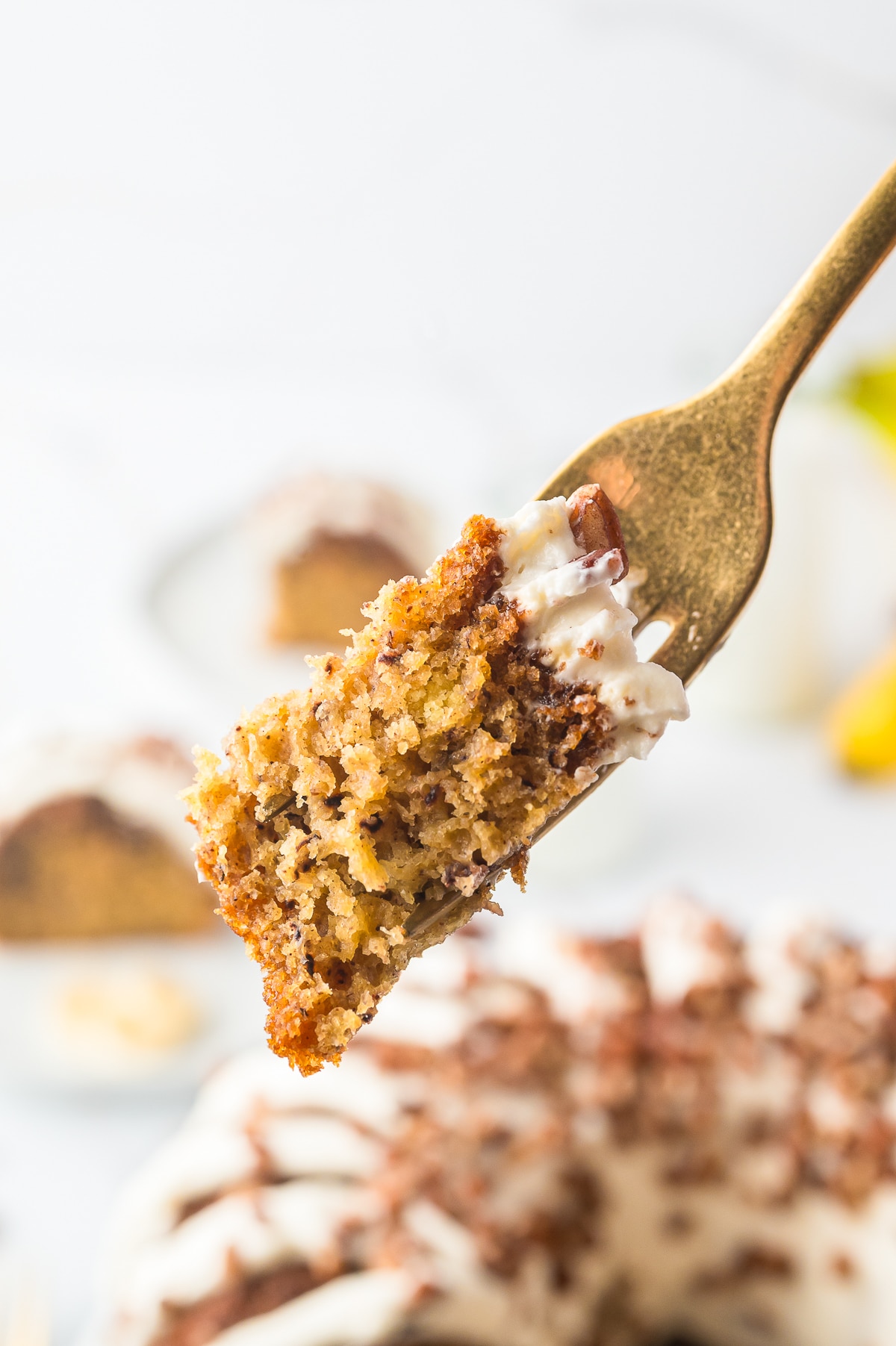 a fork holding up a bite of Banana Bundt Cake in air