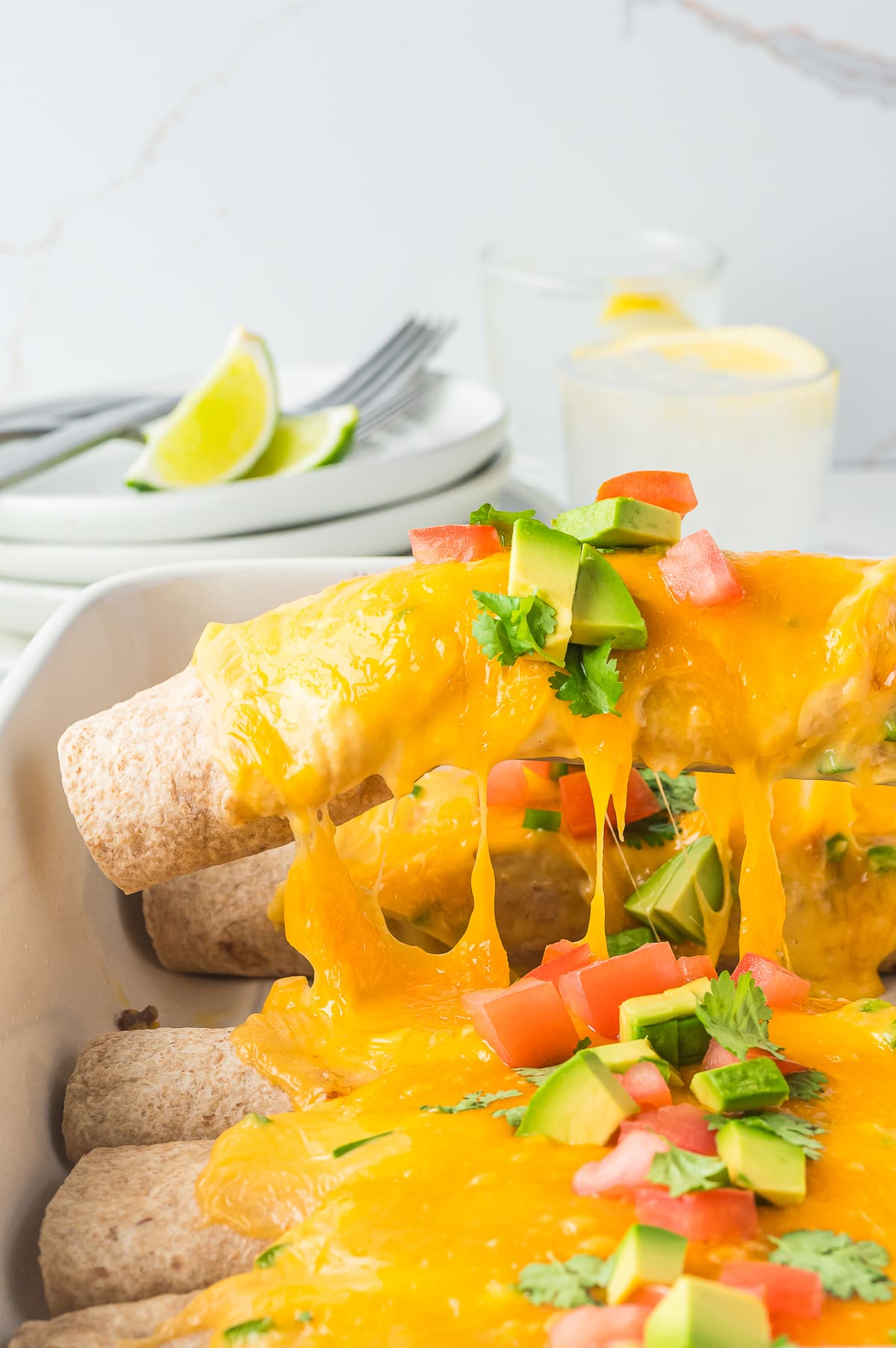 Breakfast Enchiladas being lifted out of serving dish