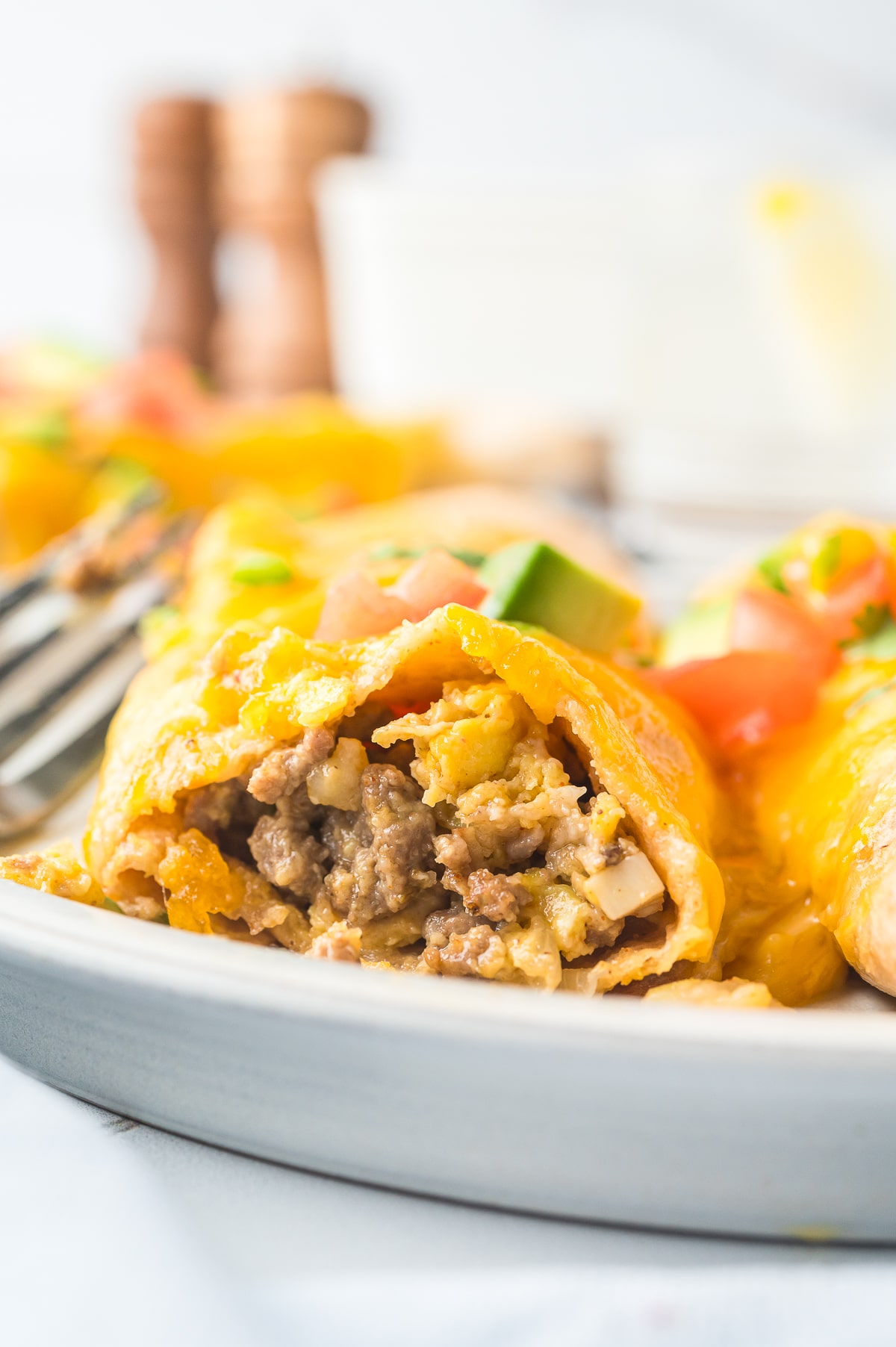 Breakfast Enchiladas on a plate cut in half to see the interior