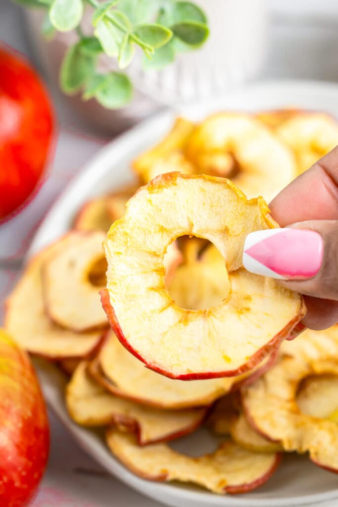 a hand holding up Apple Chips in air