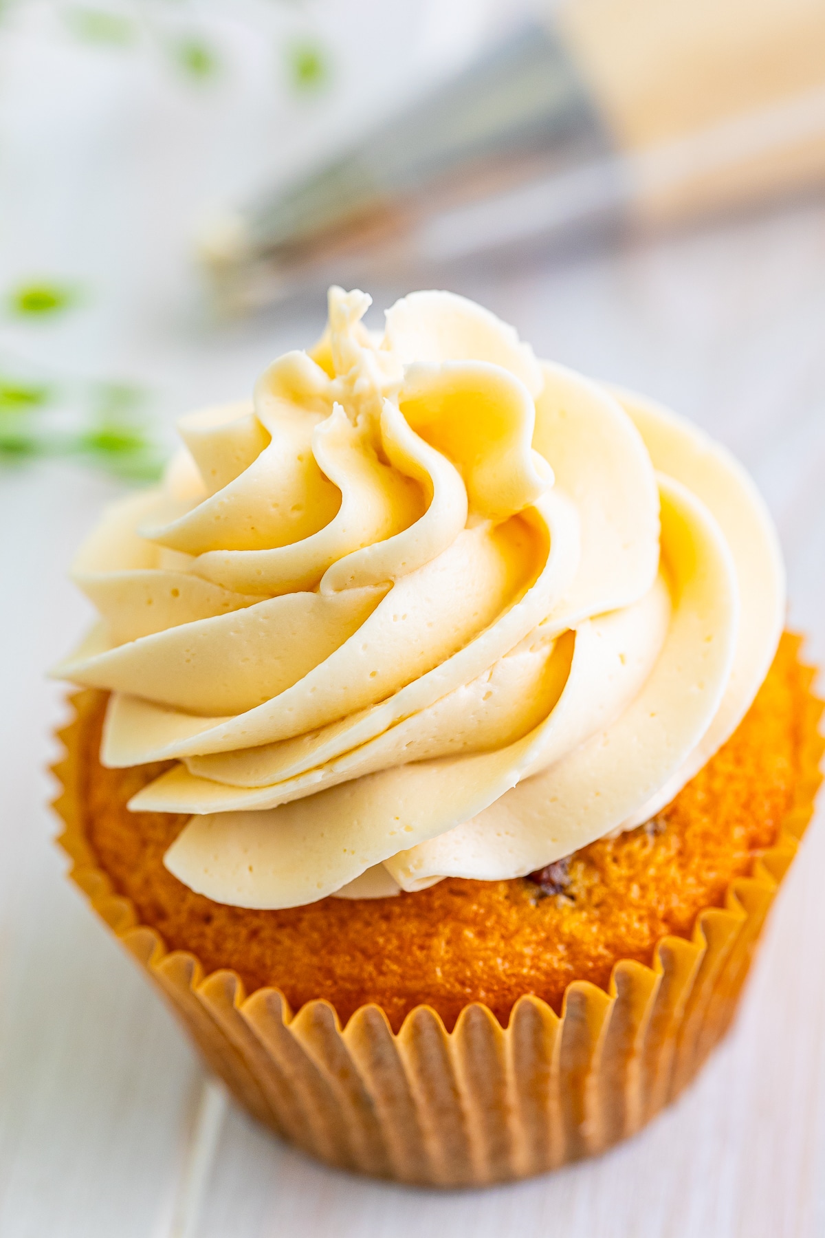 a cupcake topped with maple frosting, up close image