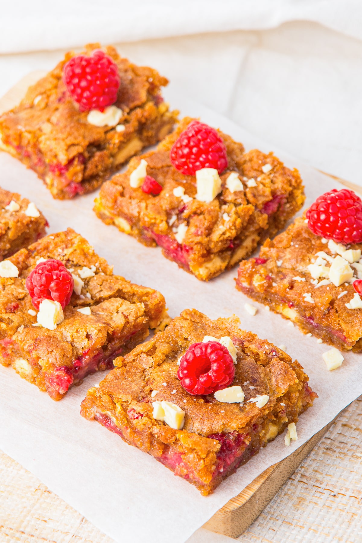 Raspberry White Chocolate Brownies on a wooden serving board