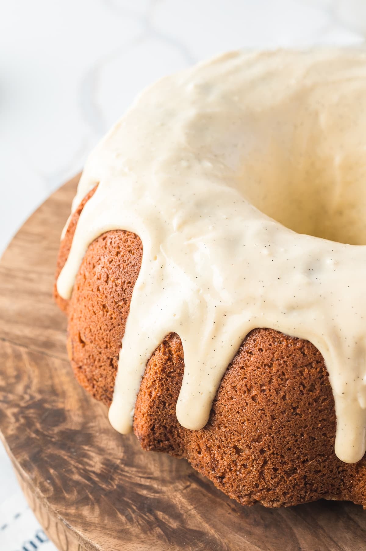 This sour cream coffee cake can be enjoyed at any time during the day, moist, cinnamony, and dripping with a luscious cream cheese glaze! #recipe from thissillygirlskitchen.com #coffeecake #sourcreamcoffeecake #cinnamon #breakfast Coffee Cake Bundt Cake on a wooden cake stand
