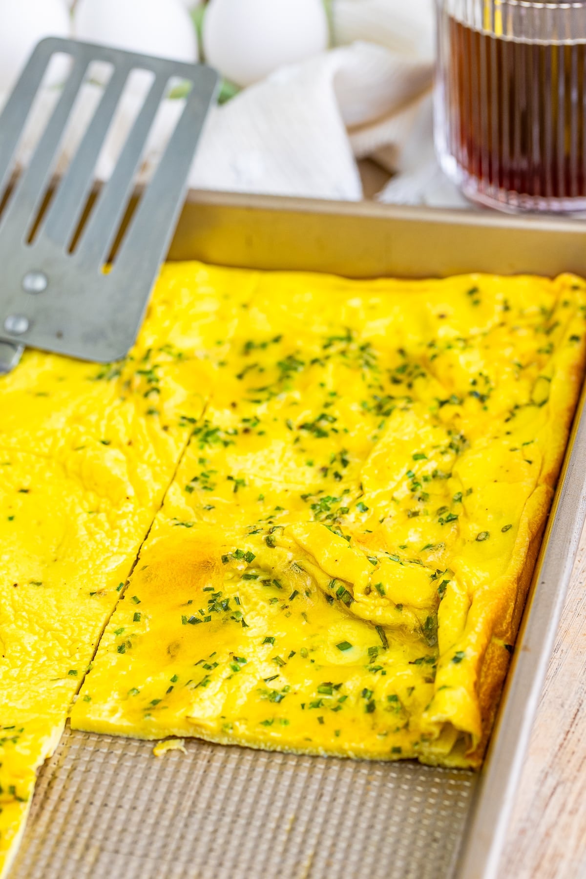 sheet pan omelet with a portion taken out in pan