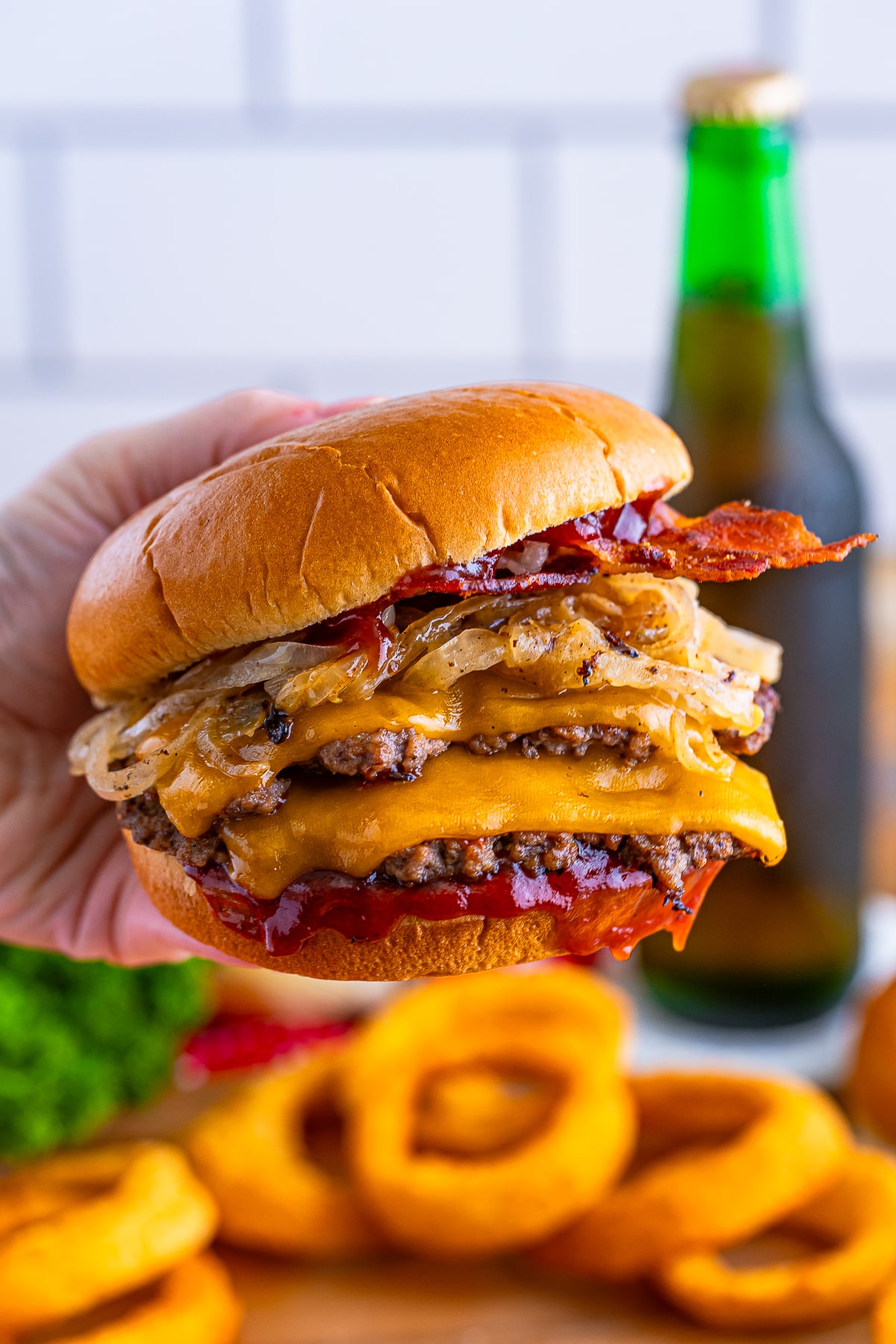 a hand holding up Blackstone Smash Burgers in air