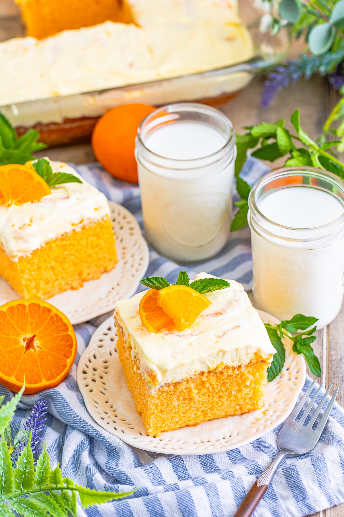 slices of Orange Creamsicle Cake with blue striped linen on serving plates