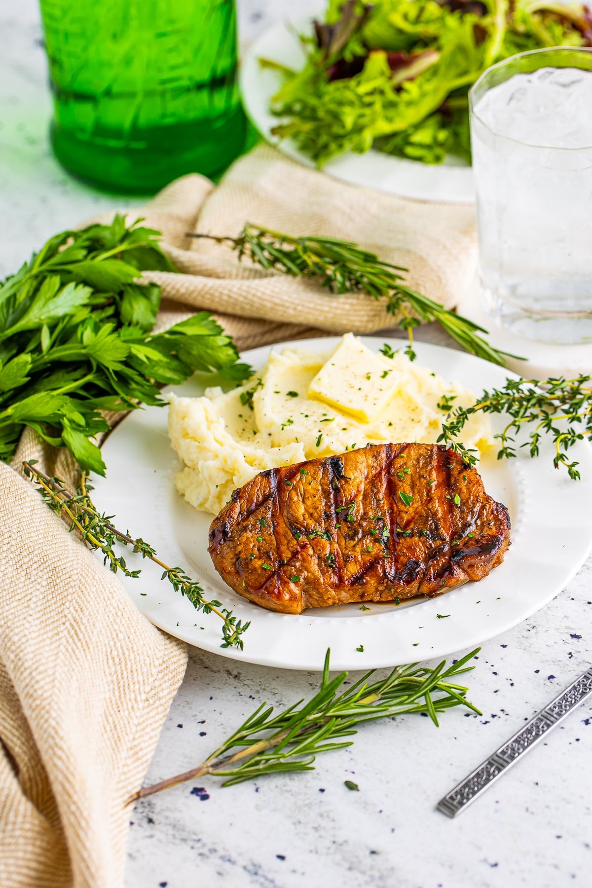 farther away image of finished Grilled Pork Chops on a white plate