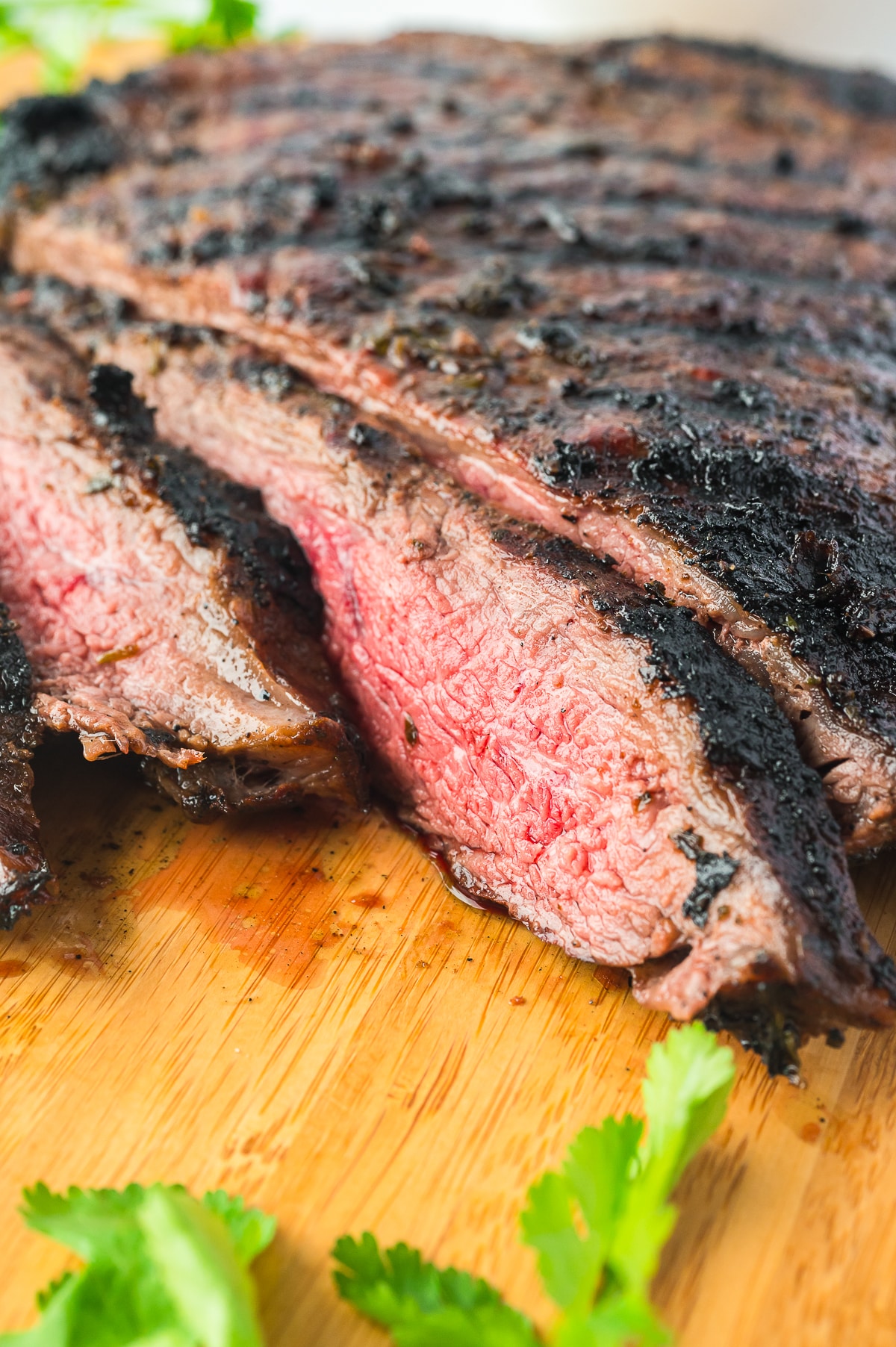 grilled flank steak sliced thinly on a wooden board