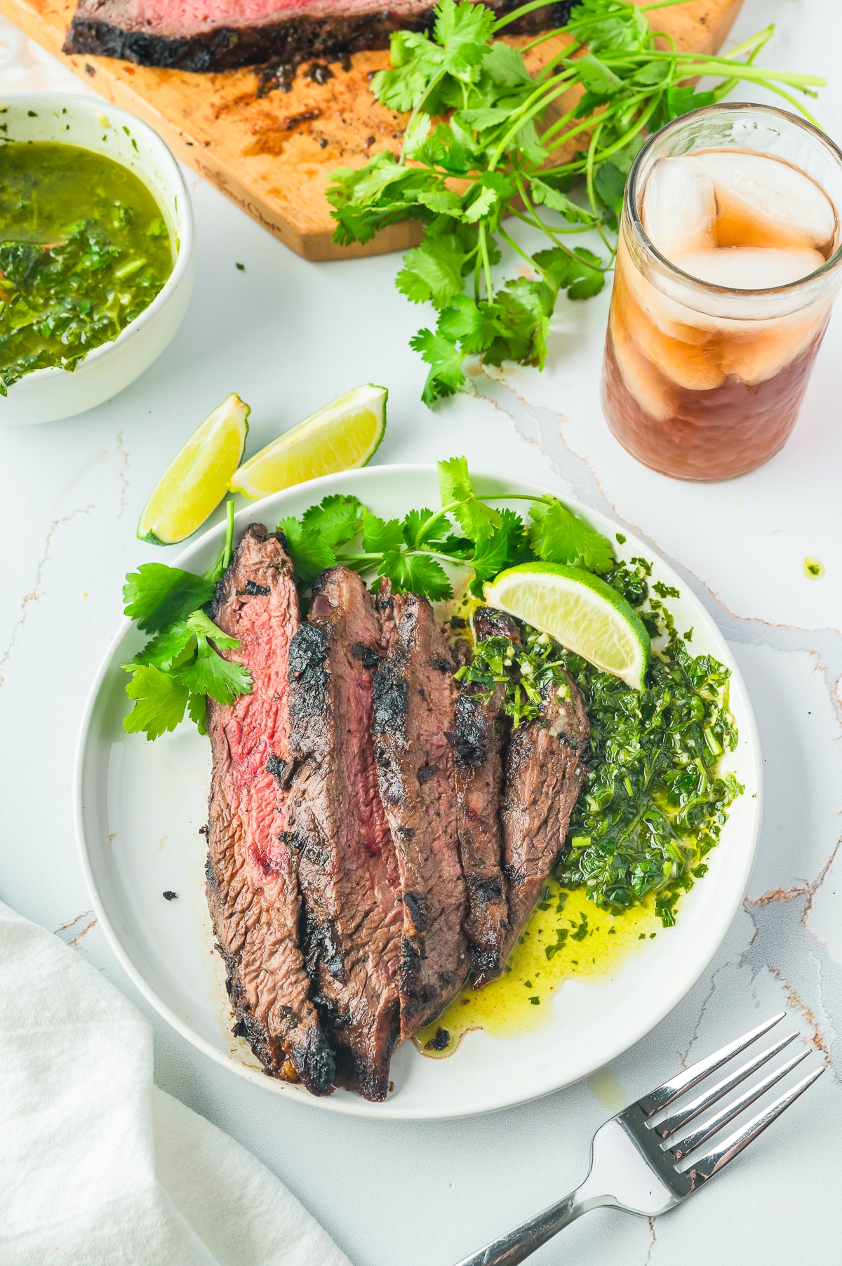 sliced grilled flank steak on a white plate