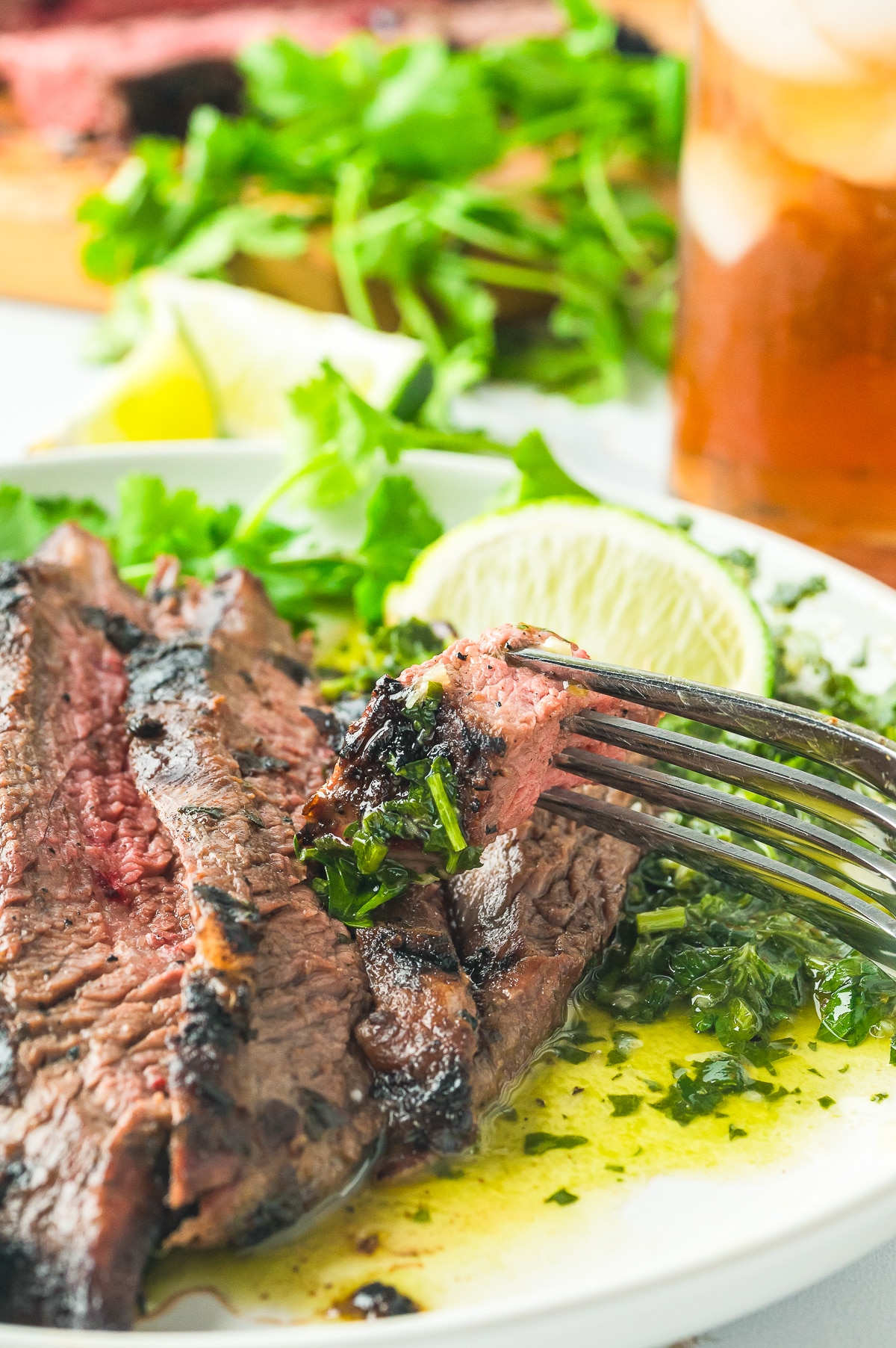 up close image of a fork piercing a piece of grilled flank steak
