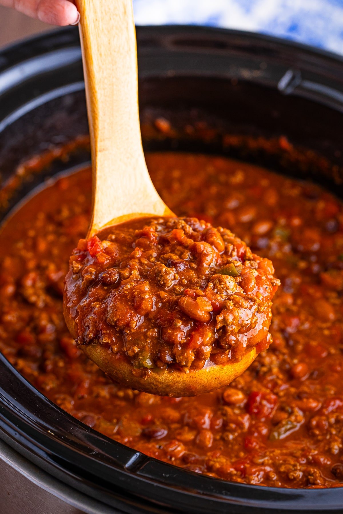 a spoon ladling Award Winning Chili Recipe out of the slow cooker in air