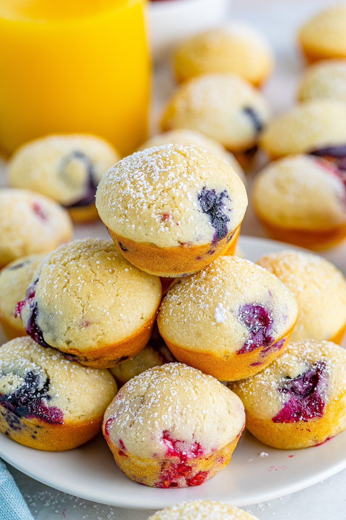 Pancake Bites with berries stacked on a white plate