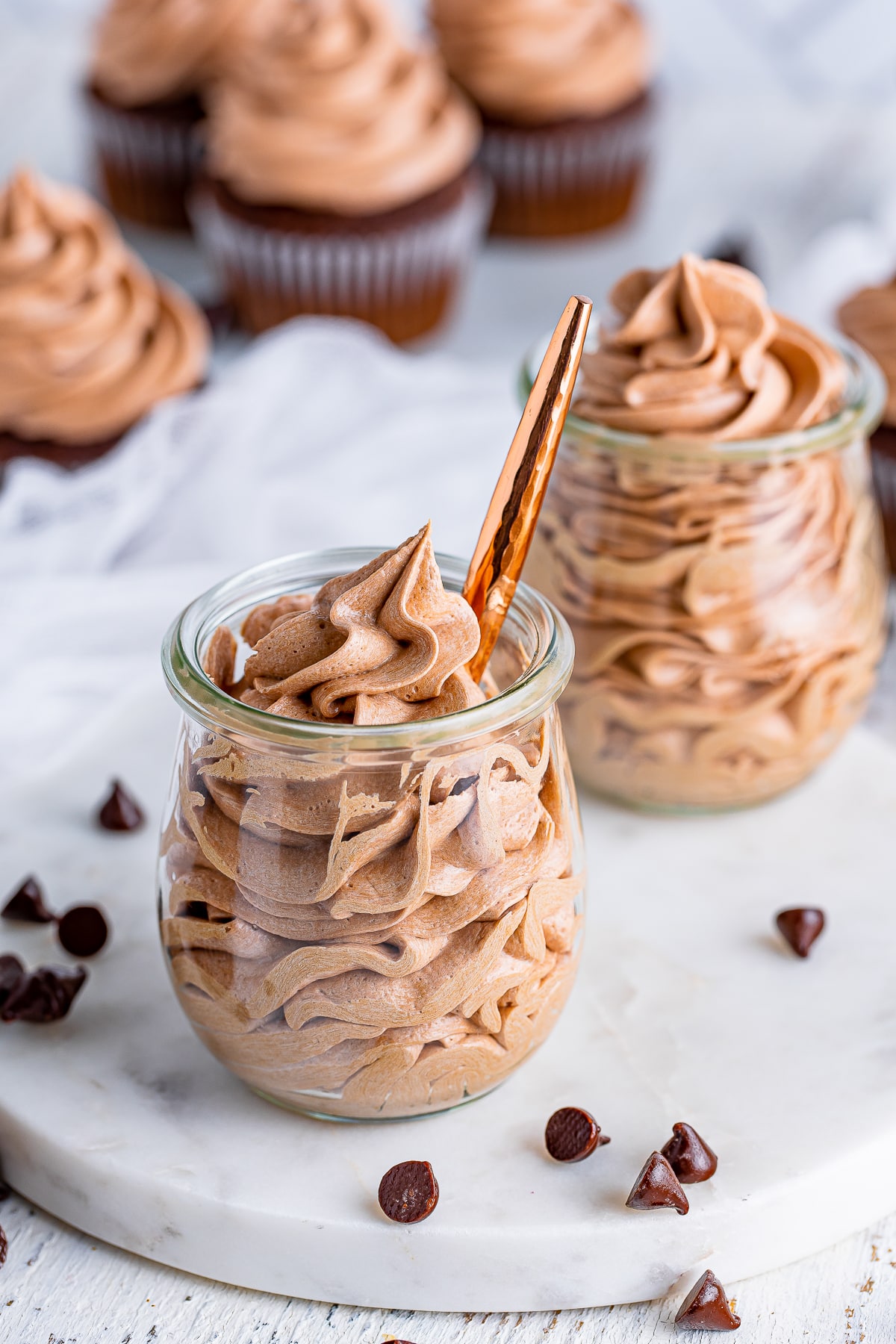 Chocolate Cream Cheese Frosting in small glass jars with a spoon inside