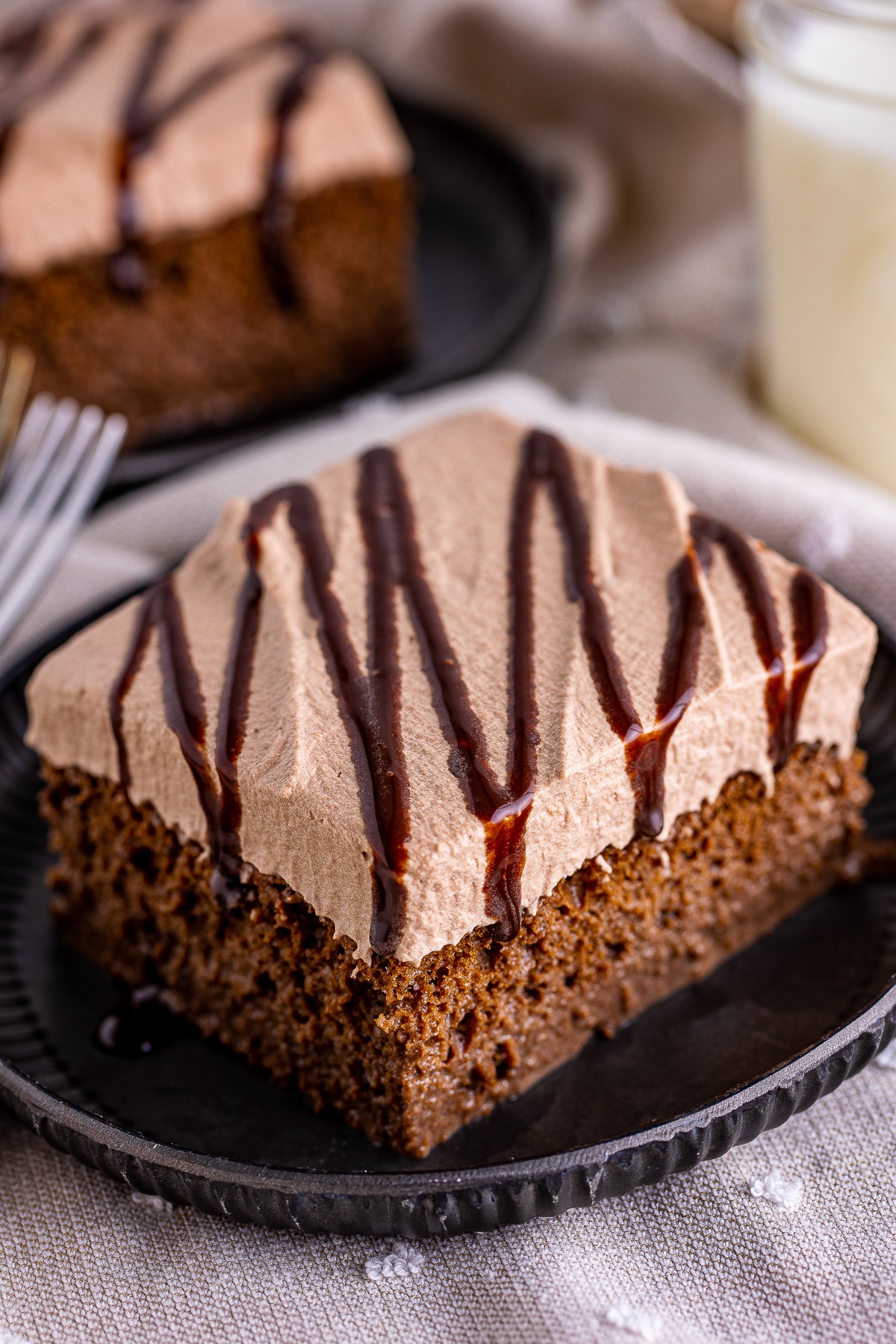 a slice of chocolate tres leches cake on a metal plate