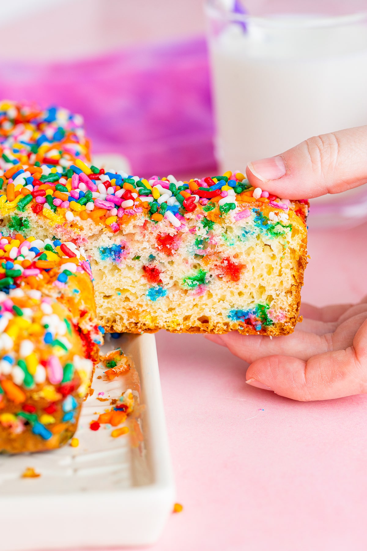 a hand pulling out a slice of Ice Cream Bread from the loaf
