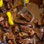 Tender Mississippi steak bites in a buttery au jus and ranch sauce with pepperoncini in a slow cooker.