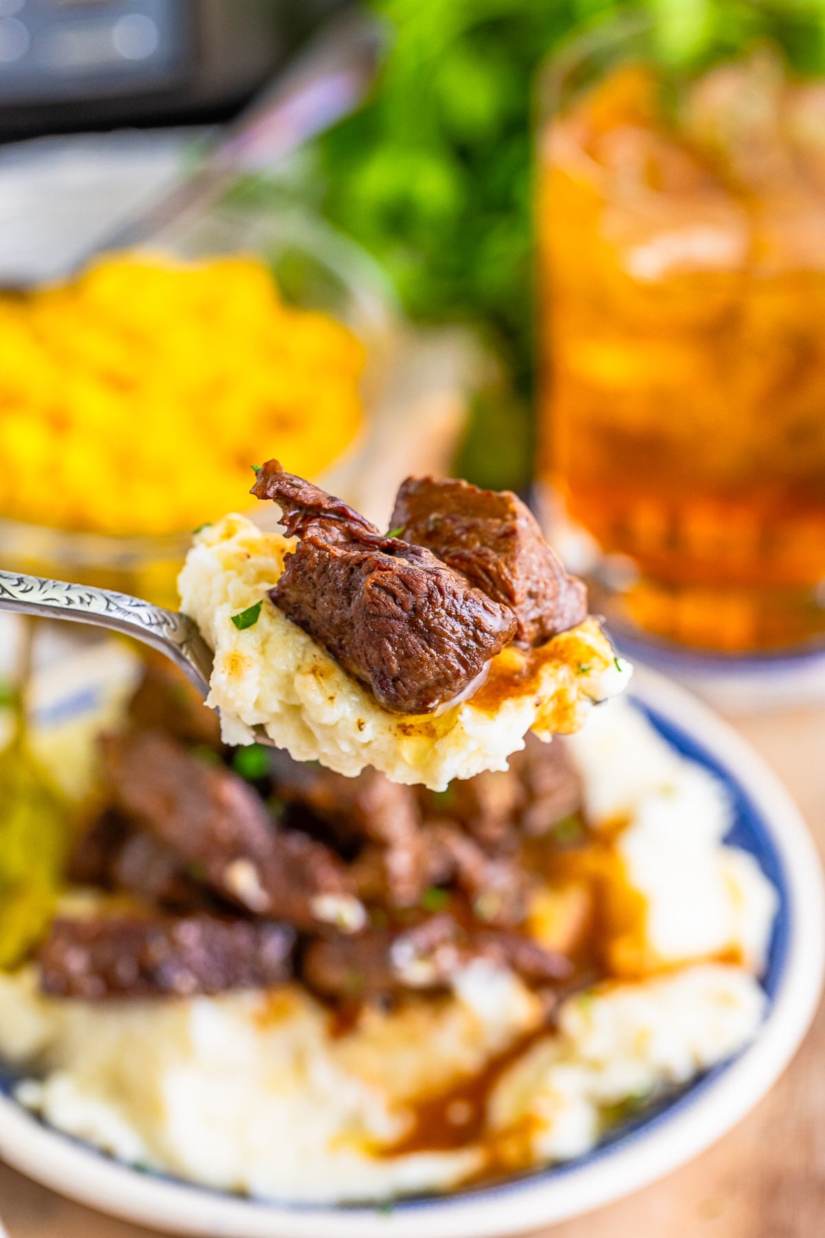 a spoon holding up a bite of Steak Bites in air