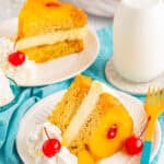 Slice of Copycat Cheesecake Factory Pineapple Upside Down Cheesecake on a white plate showing buttery cake layers, creamy cheesecake middle, and pineapple cherry topping with a glass milk bottle in the background.