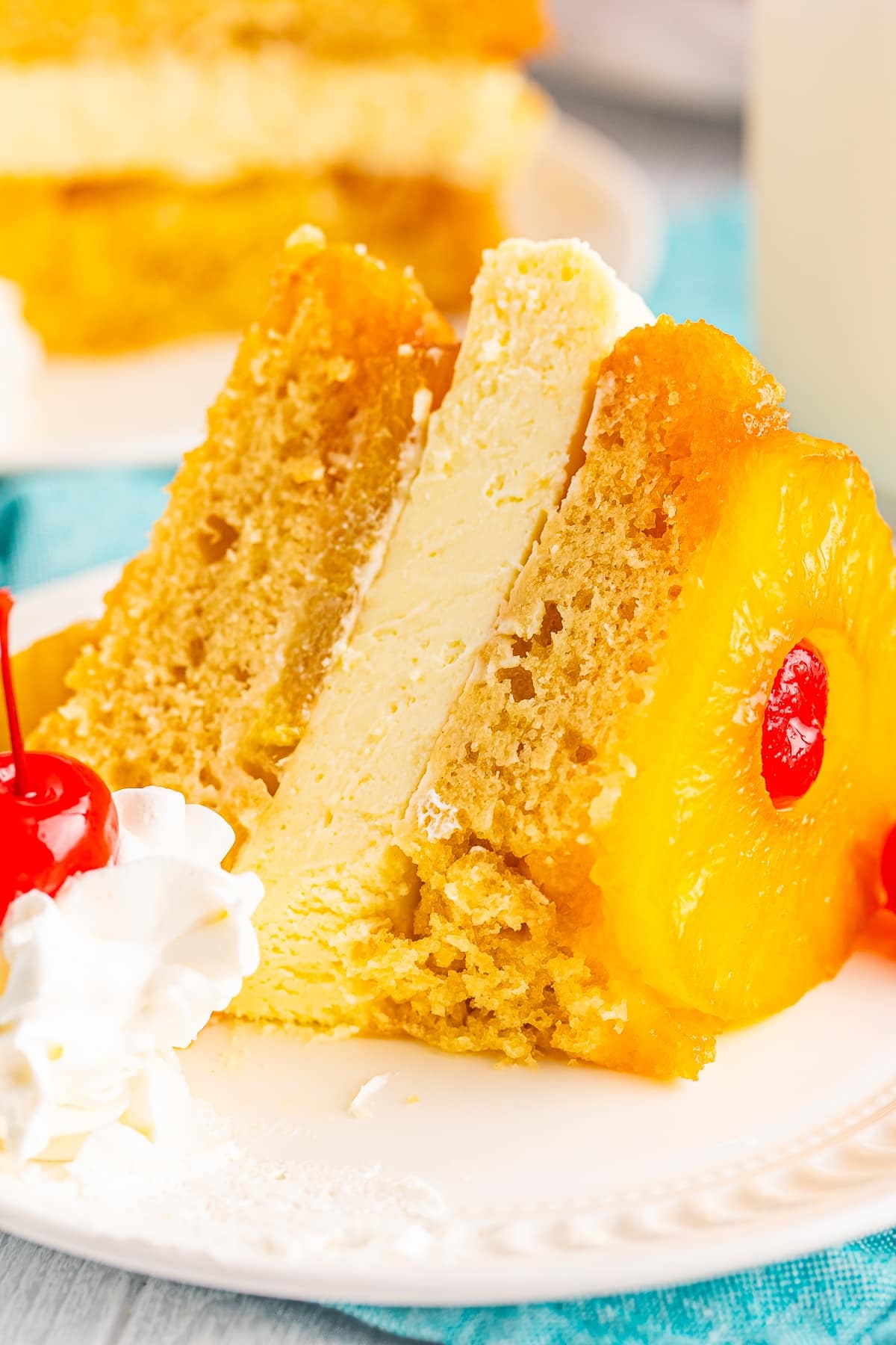 a slice of pineapple upside down cheesecake on a plate with a bite taken out