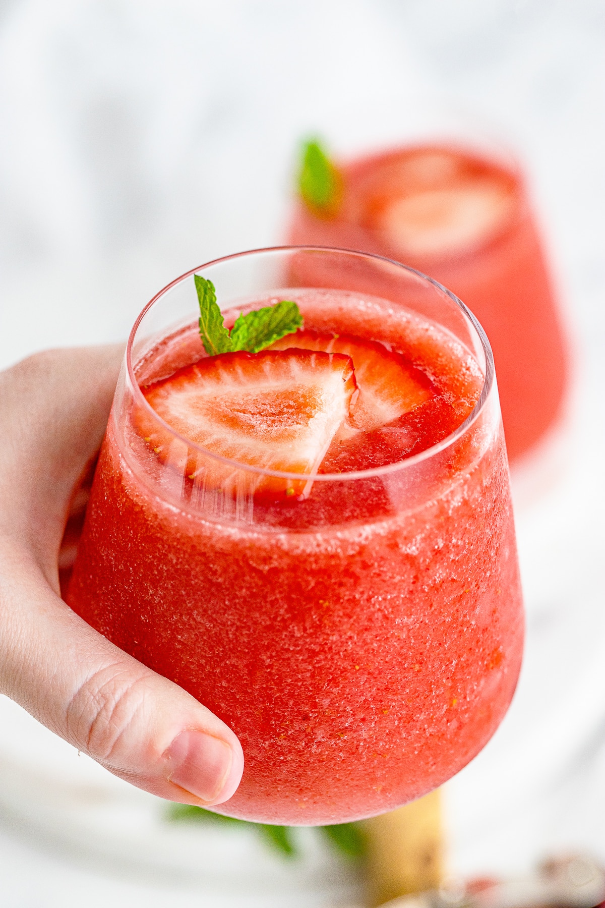 a hand holding up Wine Slushies in air