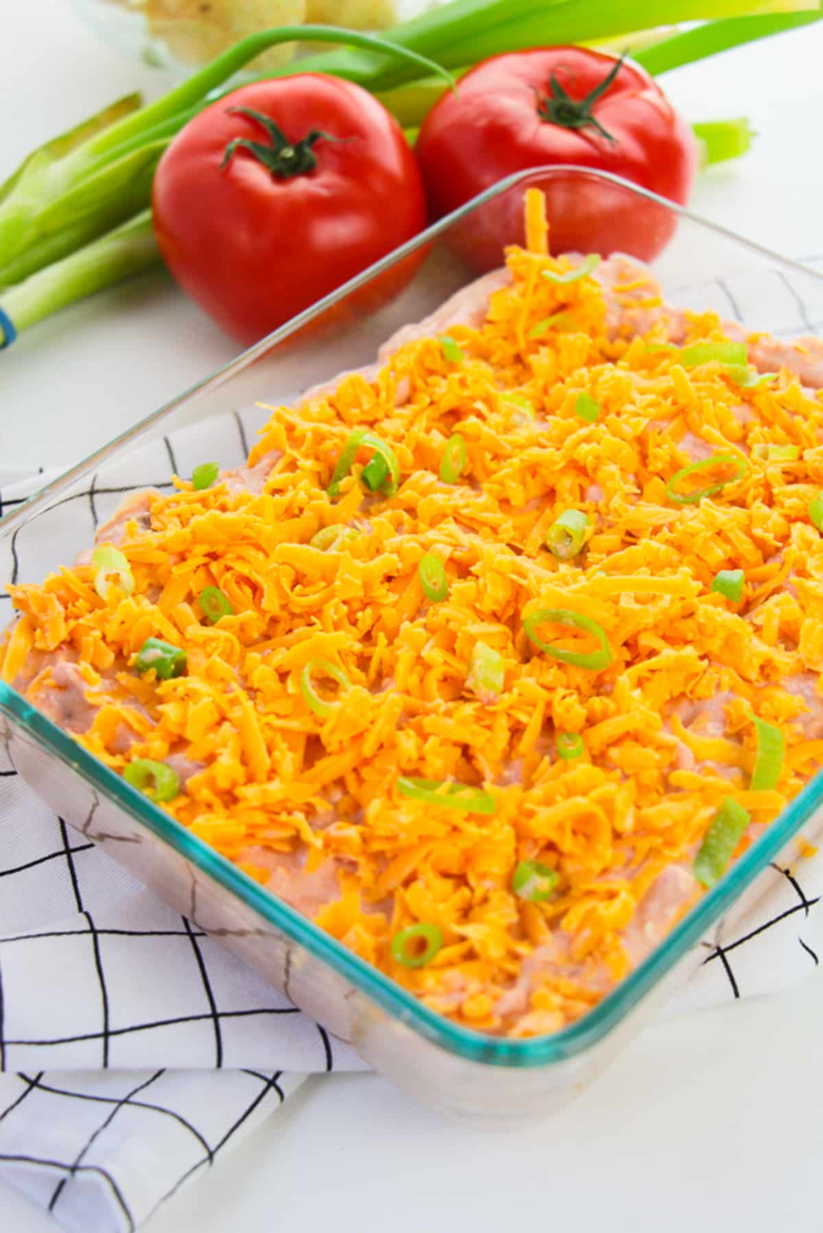 Taco Dip Recipe in a glass serving dish with garnishes