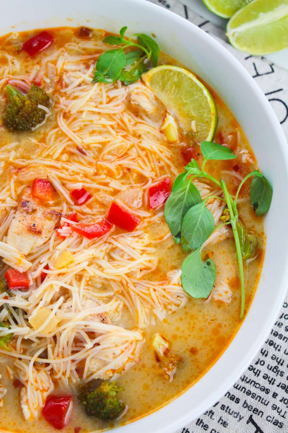 up close overhead image of Thai Red Curry Soup in a bowl with garnishes