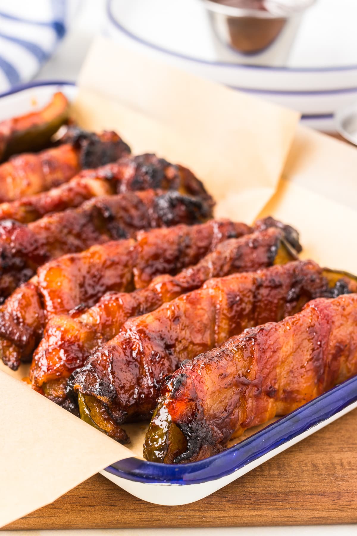 side image of Bacon Wrapped Dill Pickles lined up in a metal tray