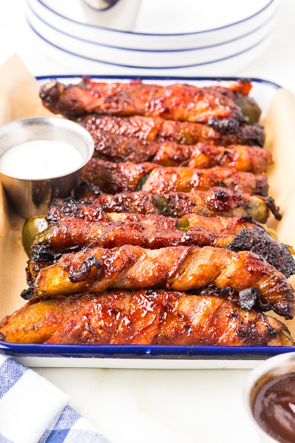 lots of Bacon Wrapped Dill Pickles in a row with ranch