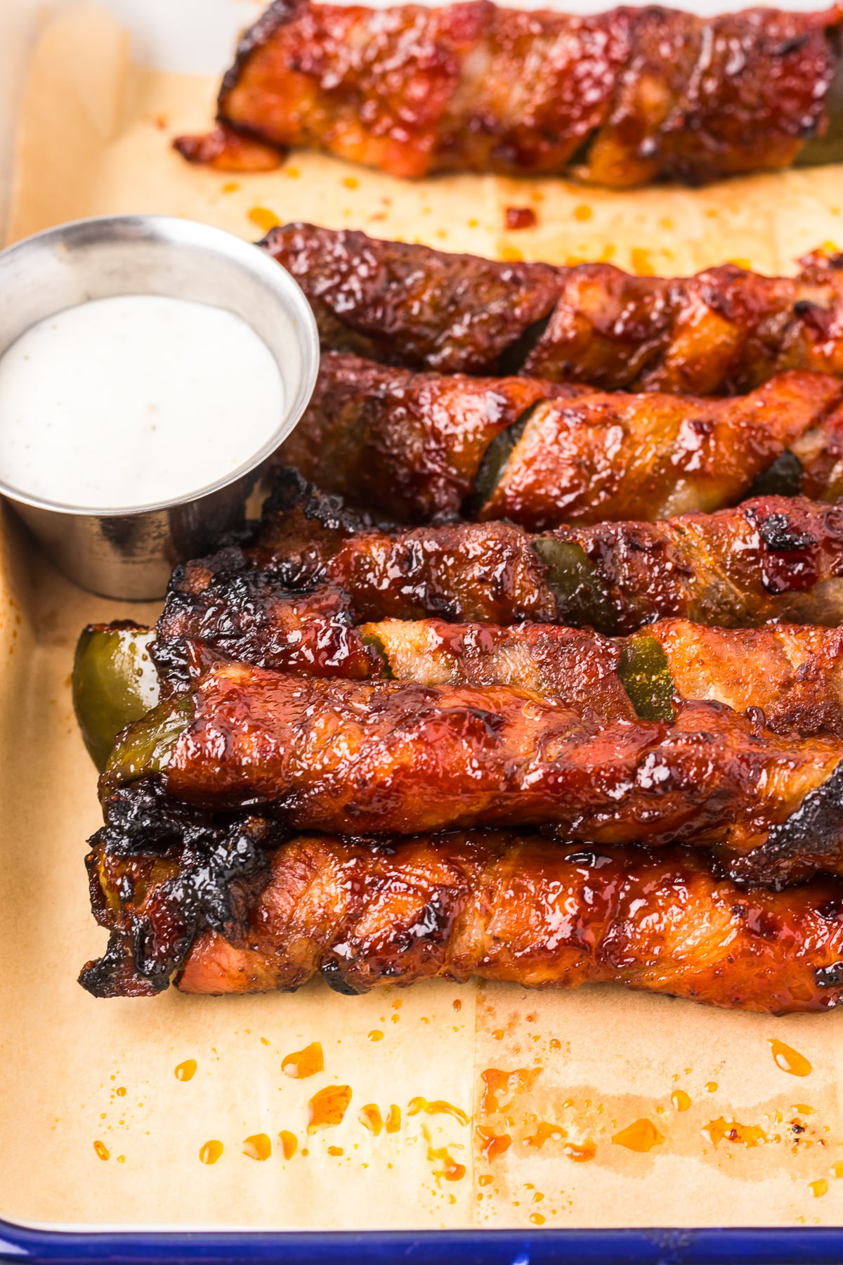 Bacon Wrapped Dill Pickles in a metal tray on parchment paper