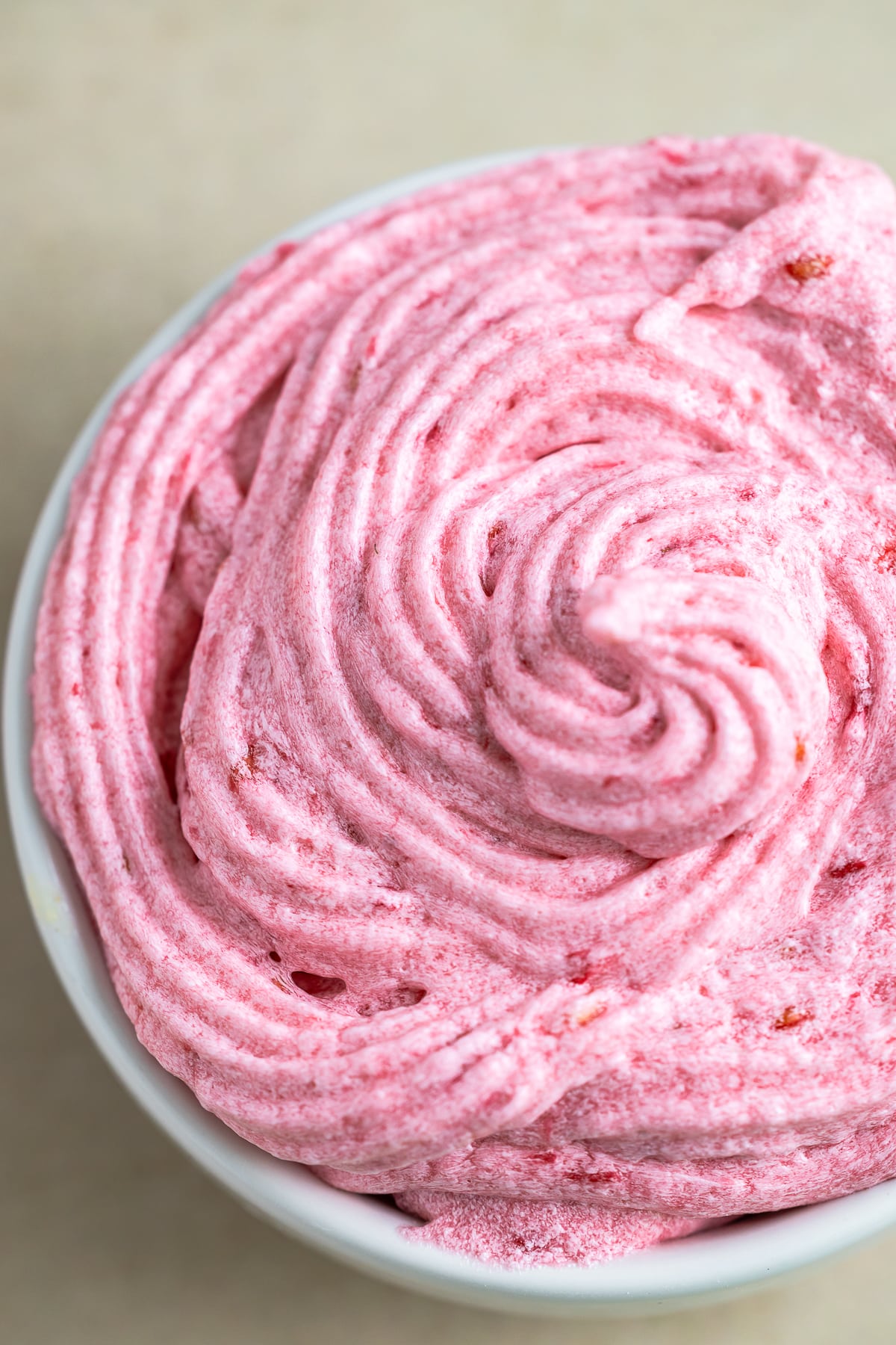 up close overhead image of Raspberry Frosting in a white bowl