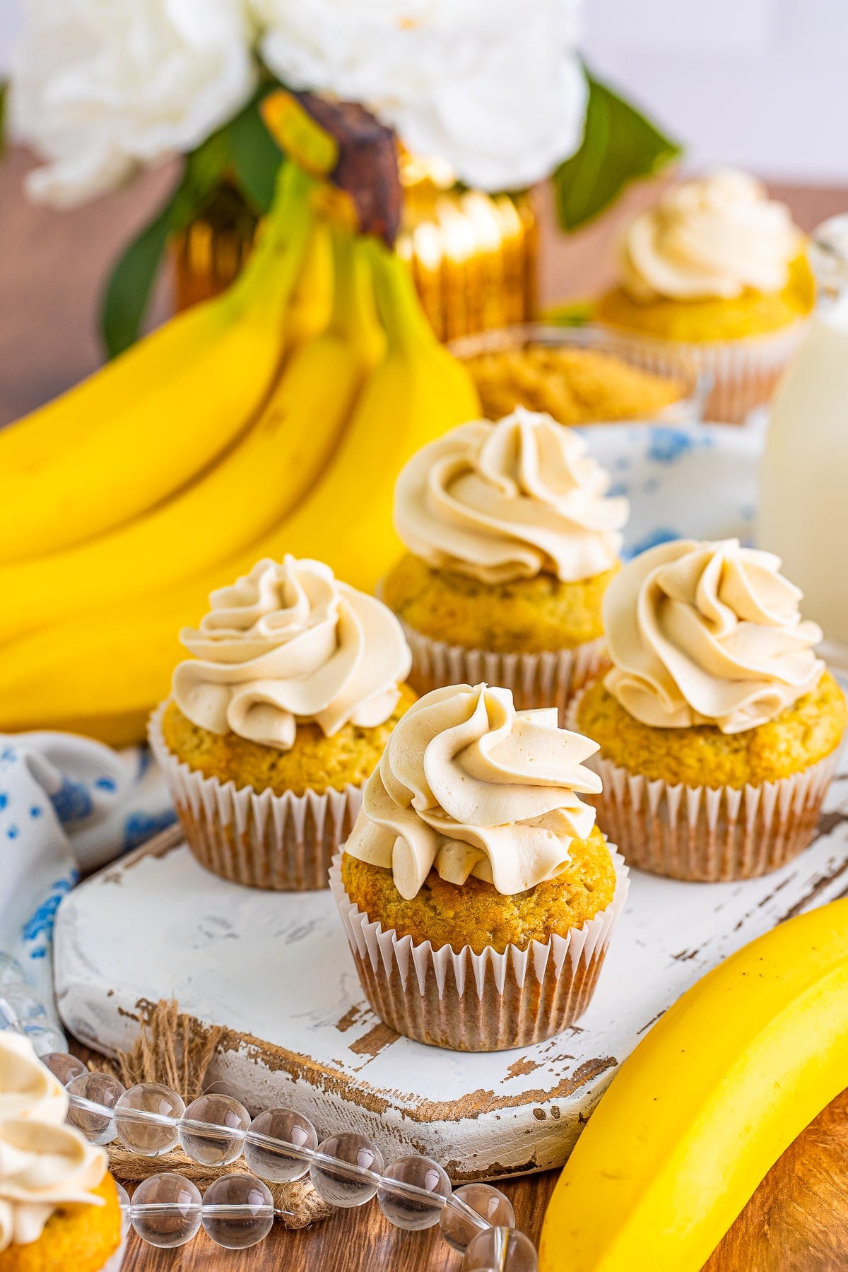 Banana Cupcakes on a white serving board with fresh bananas