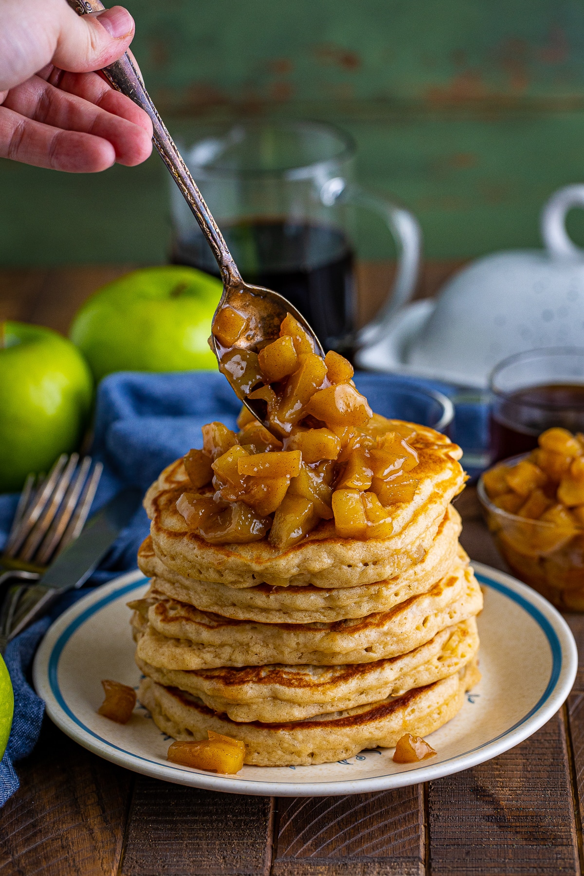 a spoon pouring some of the apple mixture on top of Apple Pancakes Recipe