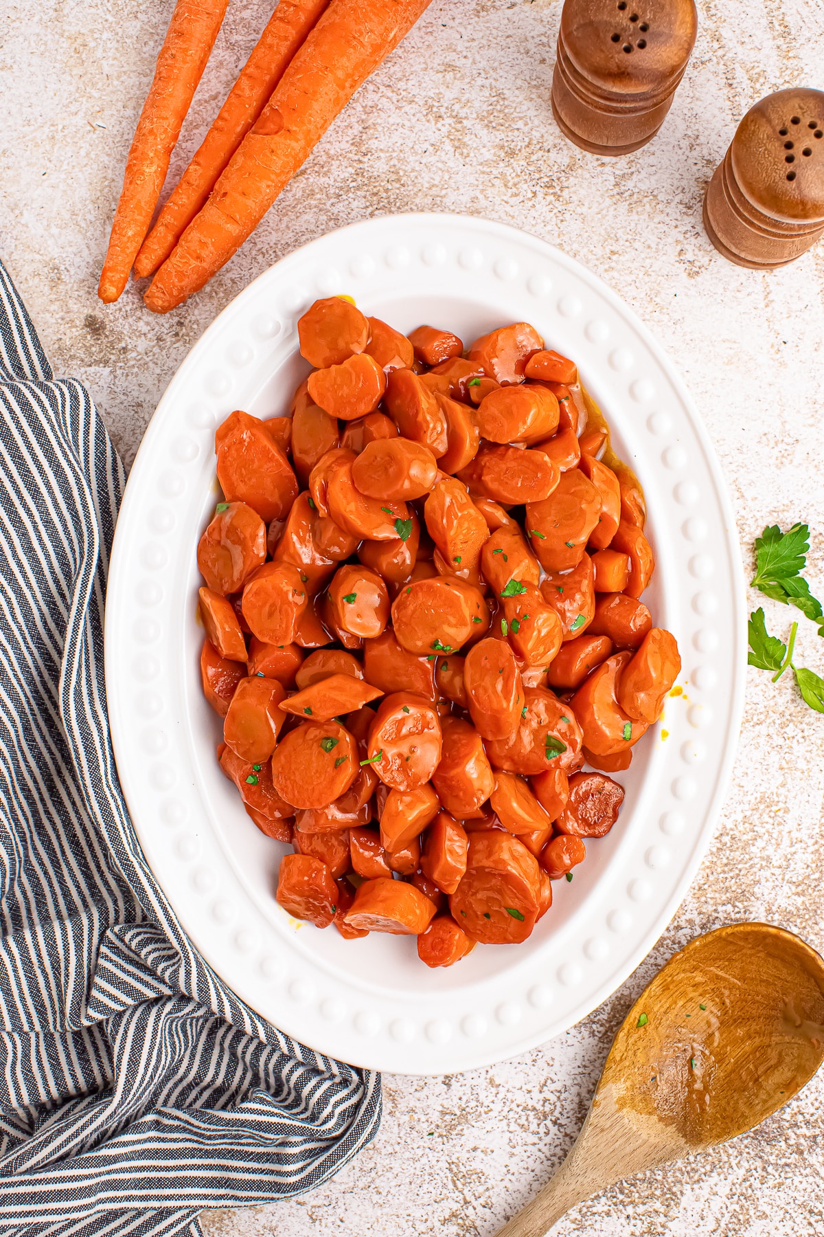 overhead image of finished Maple Glazed Carrots serving on white plate with linen
