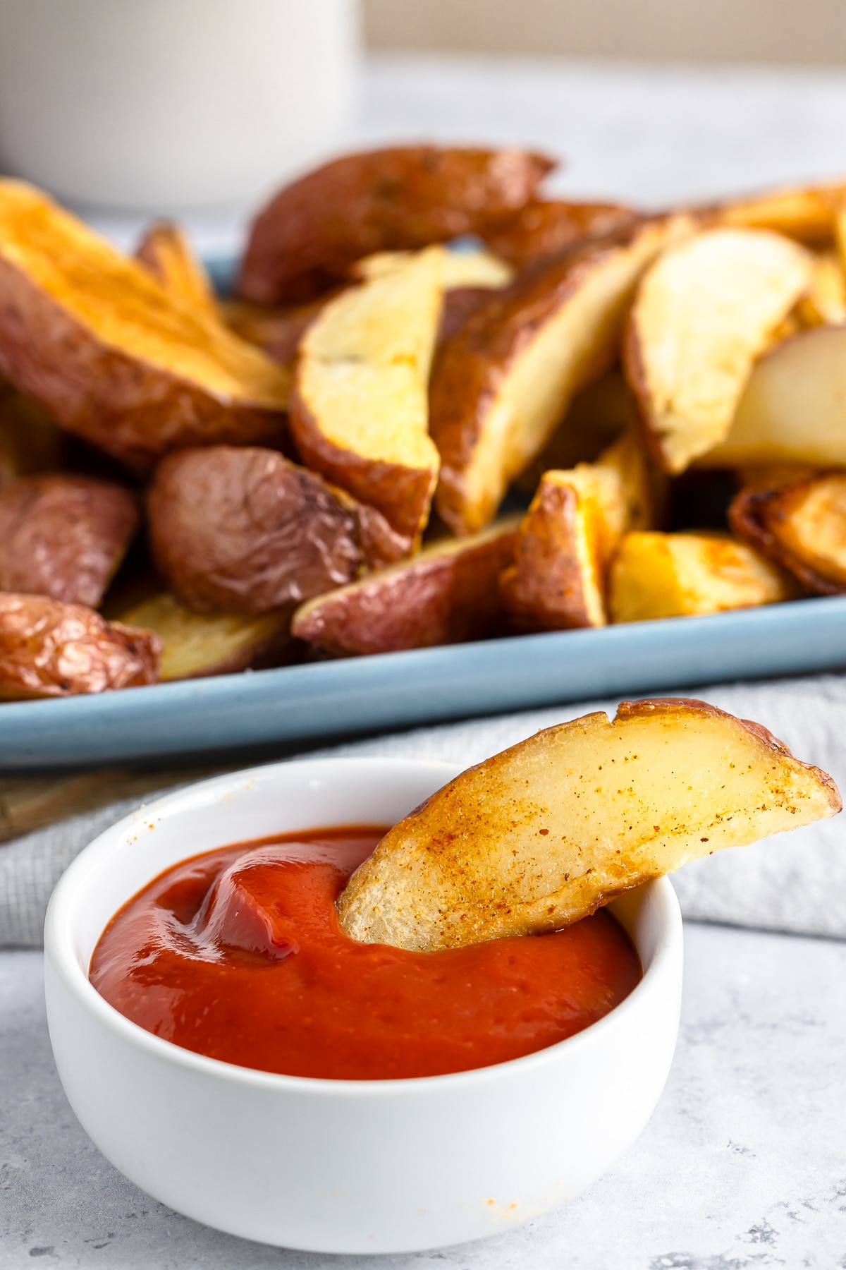 Potato Wedges Recipe resting in a bowl of ketchup