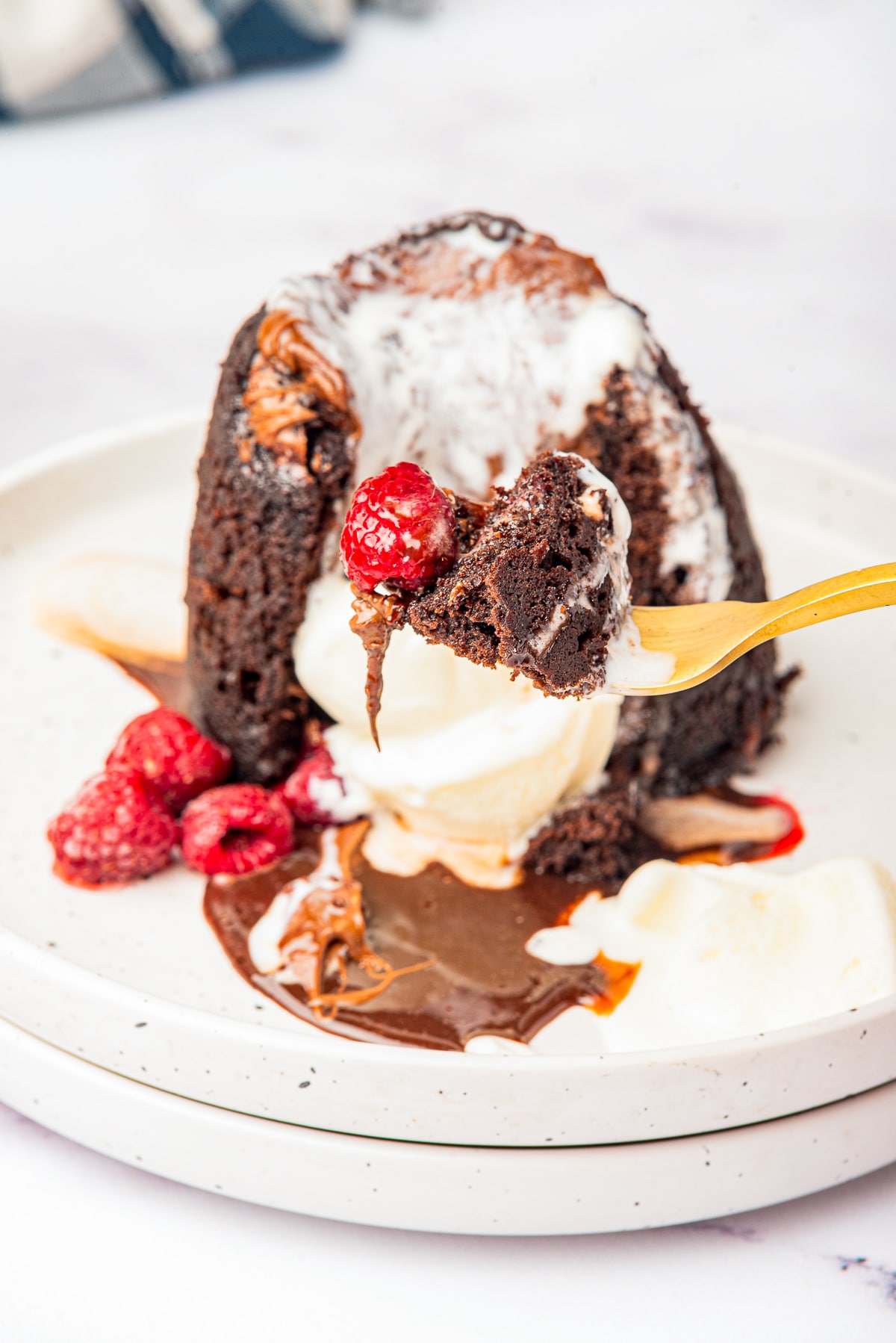 a fork holding up a bite of Microwave Lava Cake in air