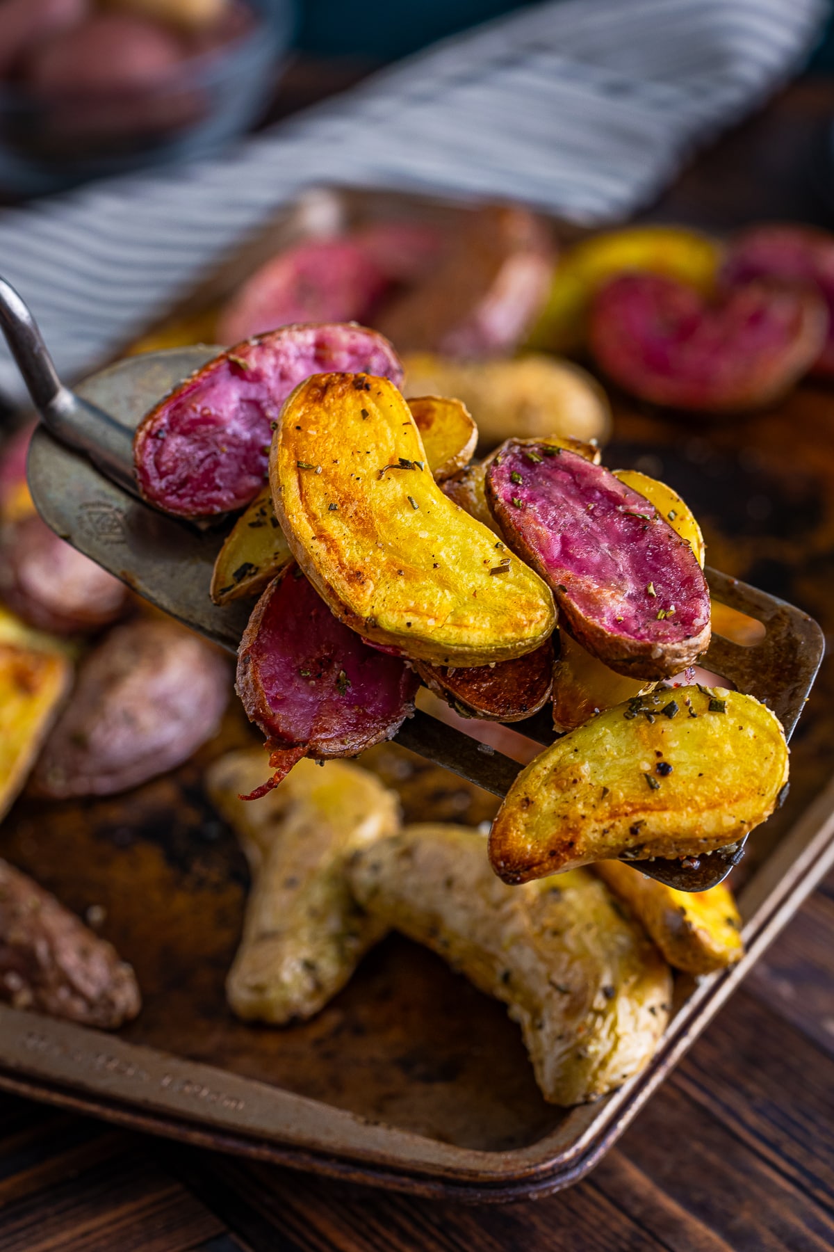 a spatula holding up Roasted Fingerlings in air
