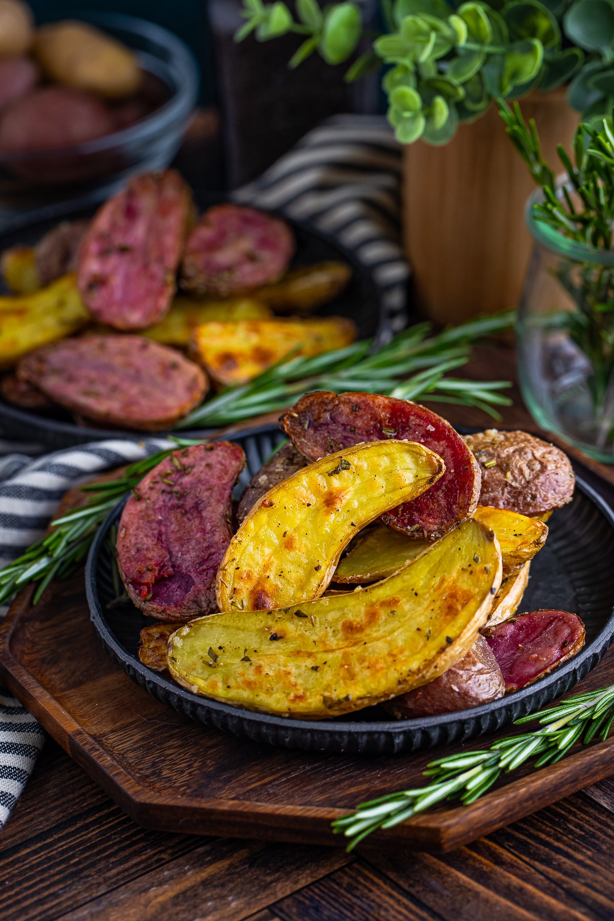 Roasted Fingerlings on a metal plate on top of a wooden serving board