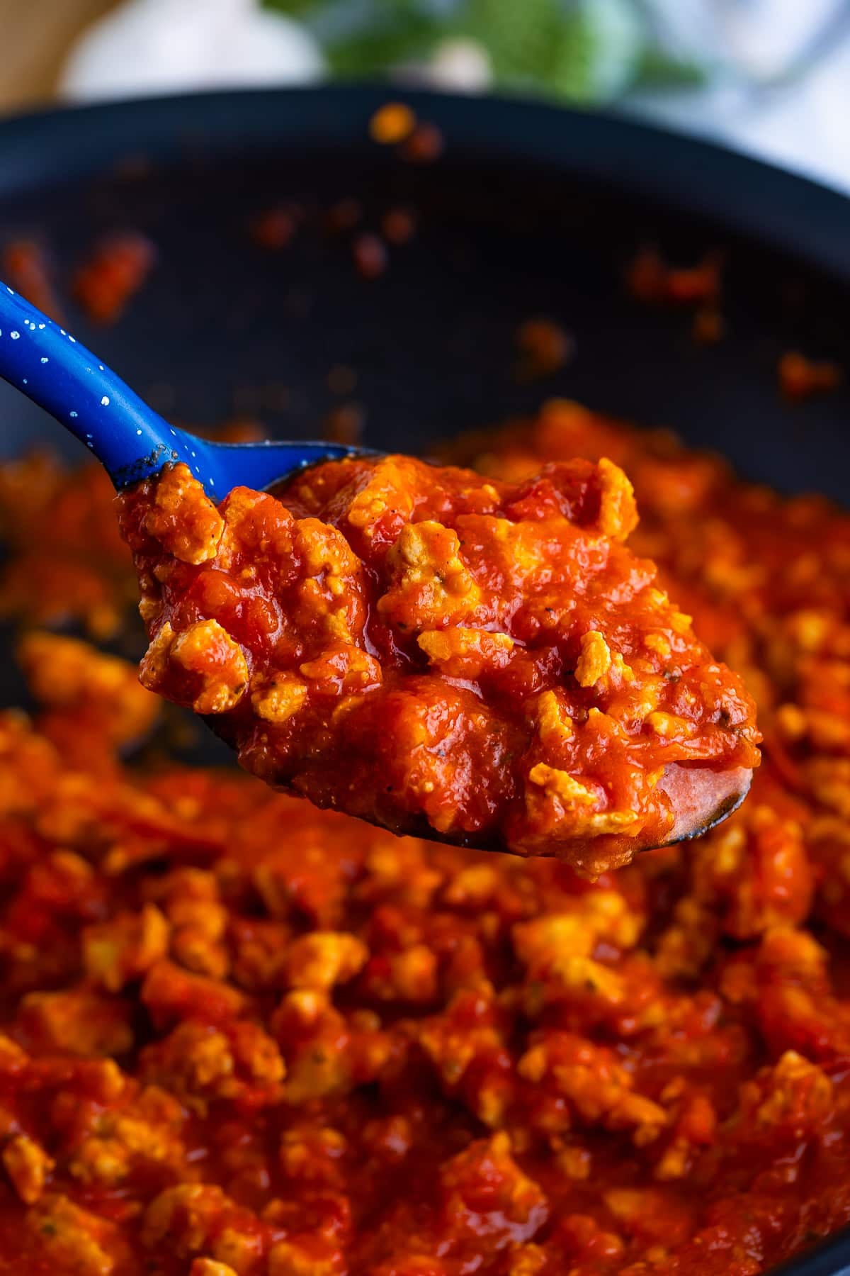 Meat Sauce made with easy homemade ground turkey sausage and bottled sauce makes this recipe easy, fast, and full of flavor. #recipe from thissillygirlskitchen.com #meatsauce #meatsaucewithturkey #spaghetti #marinara a spoon holding up some of the sauce for Turkey Spaghetti in air